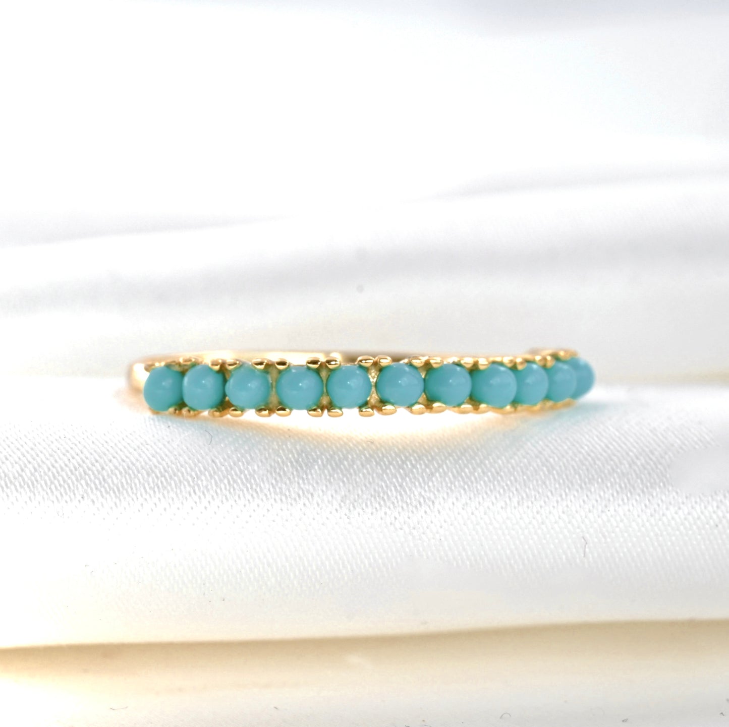front-close up view of the gold ring with vibrant turquoise stones
