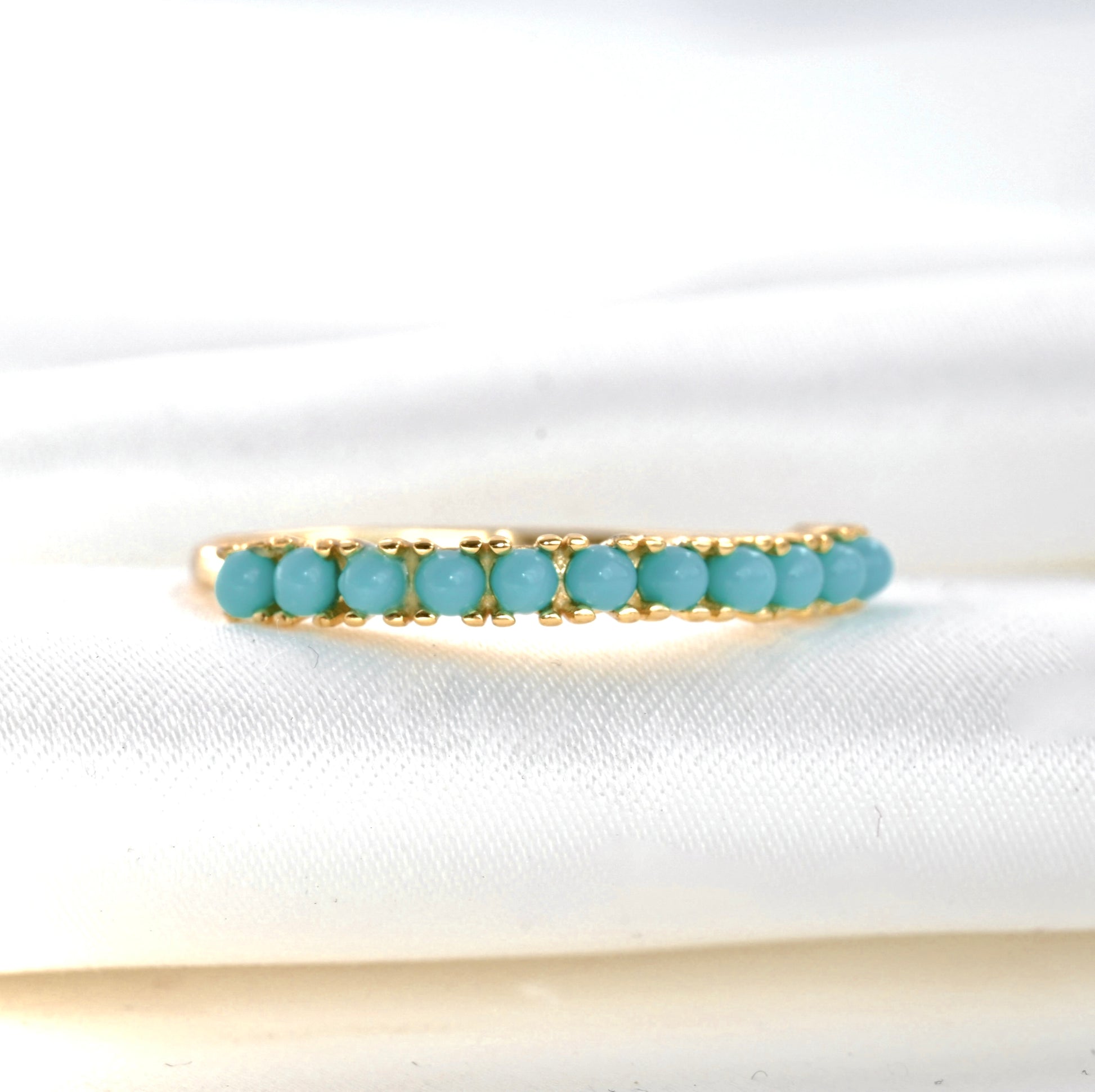 front-close up view of the gold ring with vibrant turquoise stones