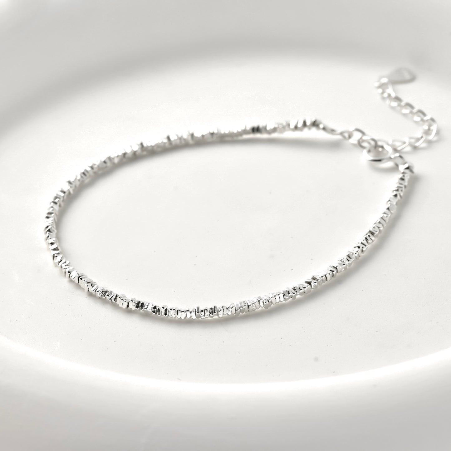 Silver square beaded bracelet  on a light gray background