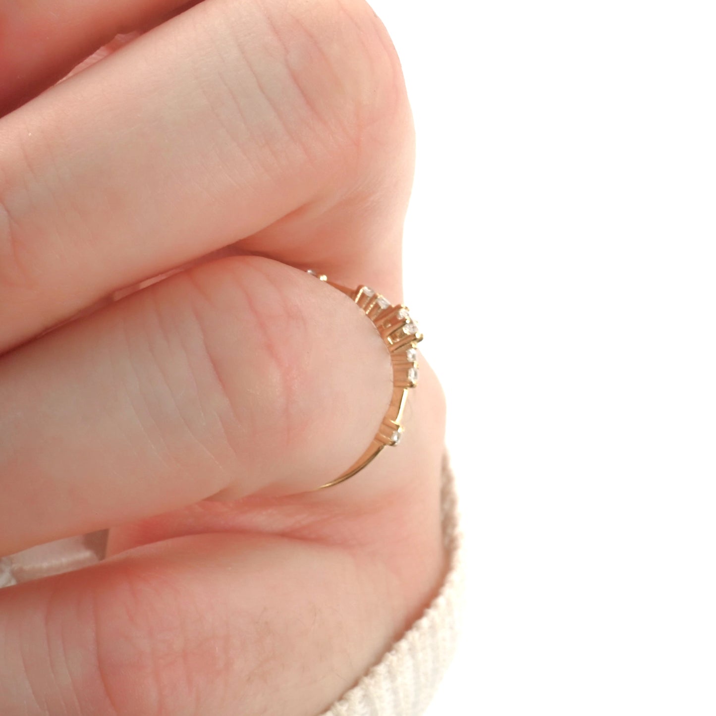 Gold ring on a person's finger against a white background