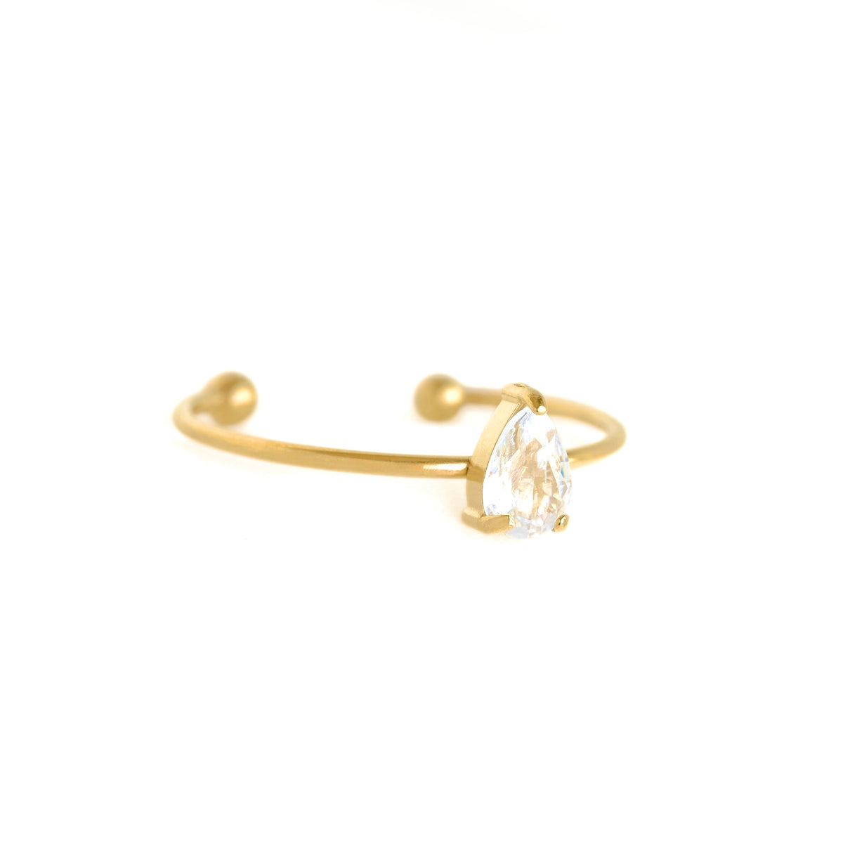 A gold open cuff ring featuring a pear-cut clear crystal pendant, set against a solid white background.