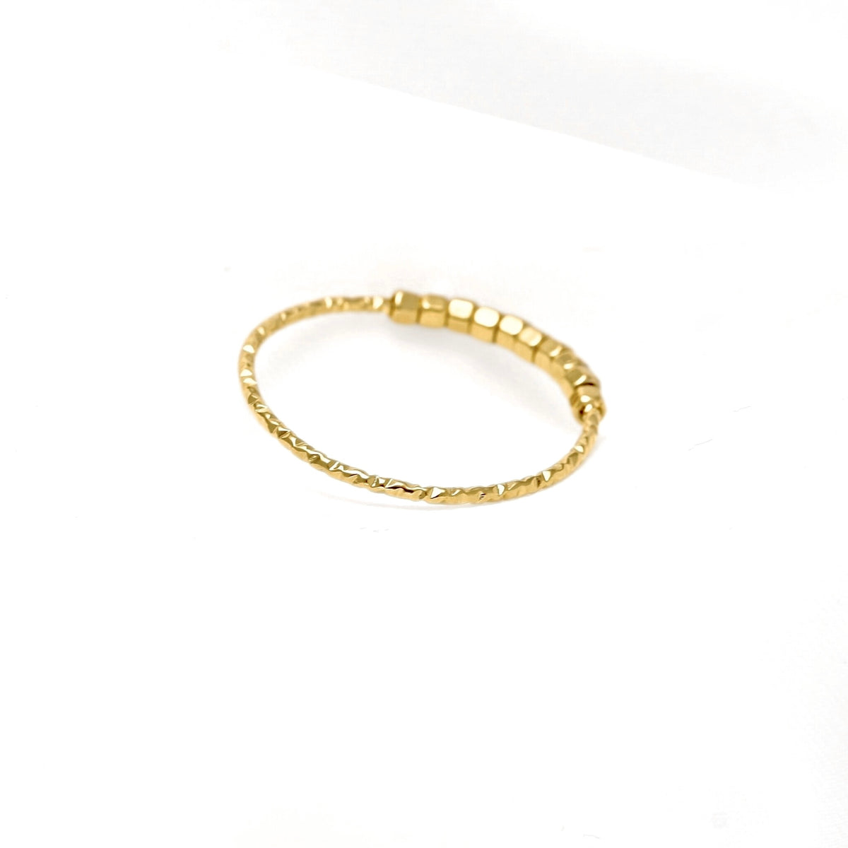 A delicate gold-plated ring with a textured, twisted design and small cube beads, shown on a plain white background.