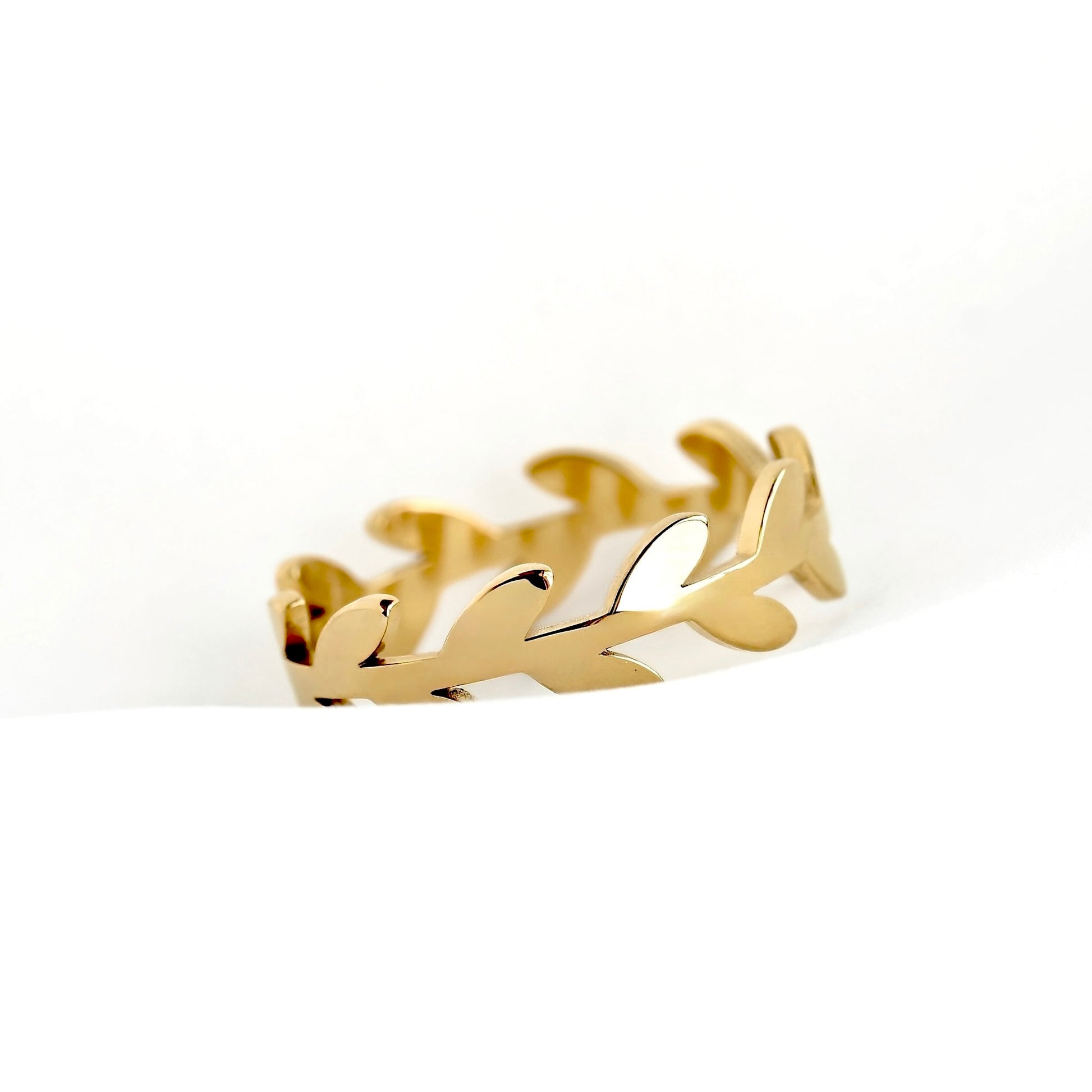 A gold leaf branch ring with a polished finish, displayed on a clean white background.