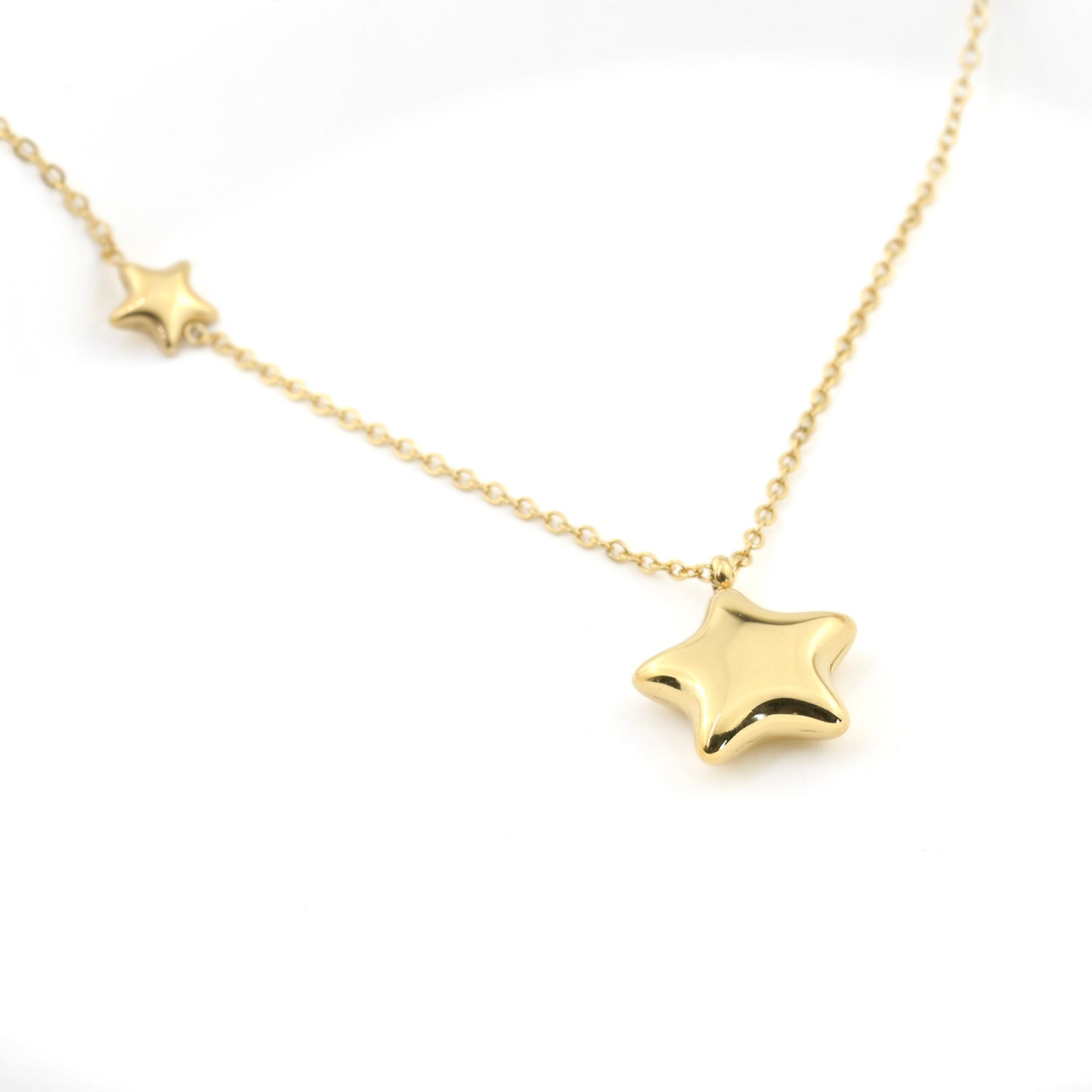 Gold  baloon sta pendant necklace on a white background