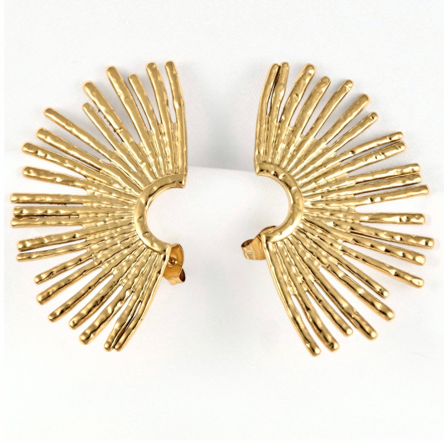 A pair of gold-toned fan-shaped earrings with textured, radiating rod-like details, displayed on a white background.