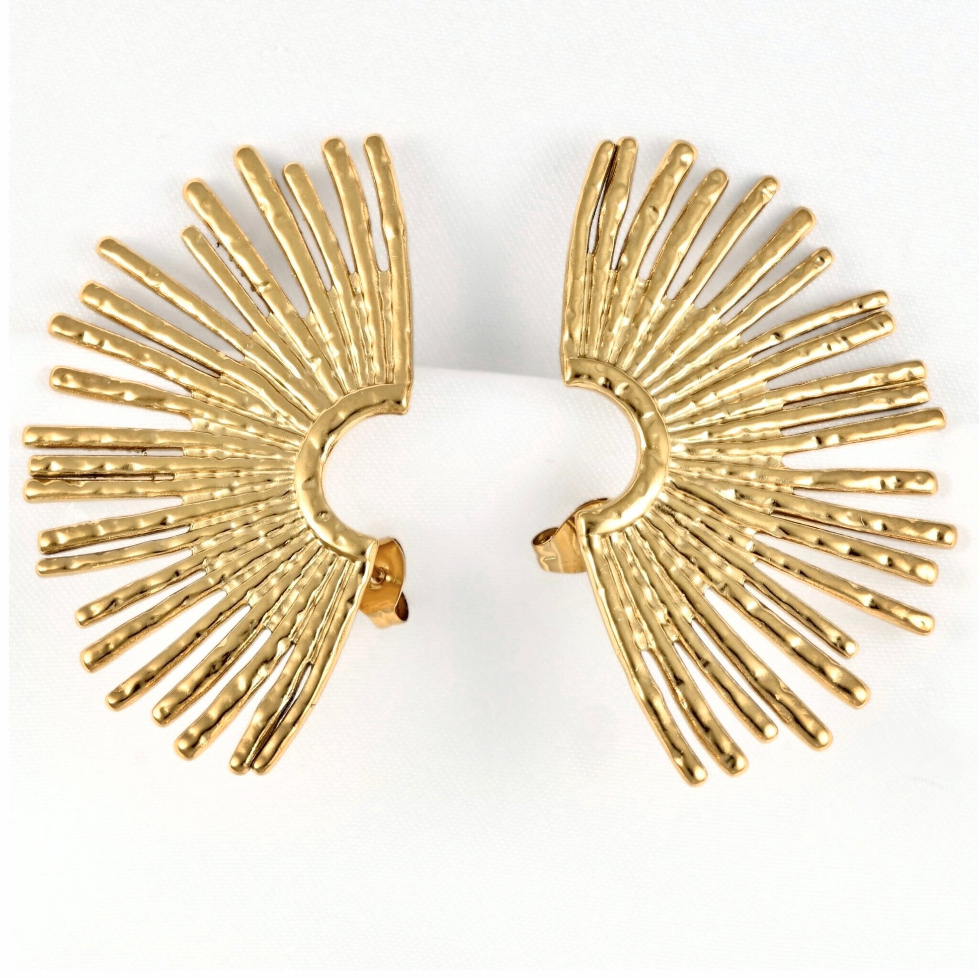 A pair of gold-toned fan-shaped earrings with textured, radiating rod-like details, displayed on a white background.