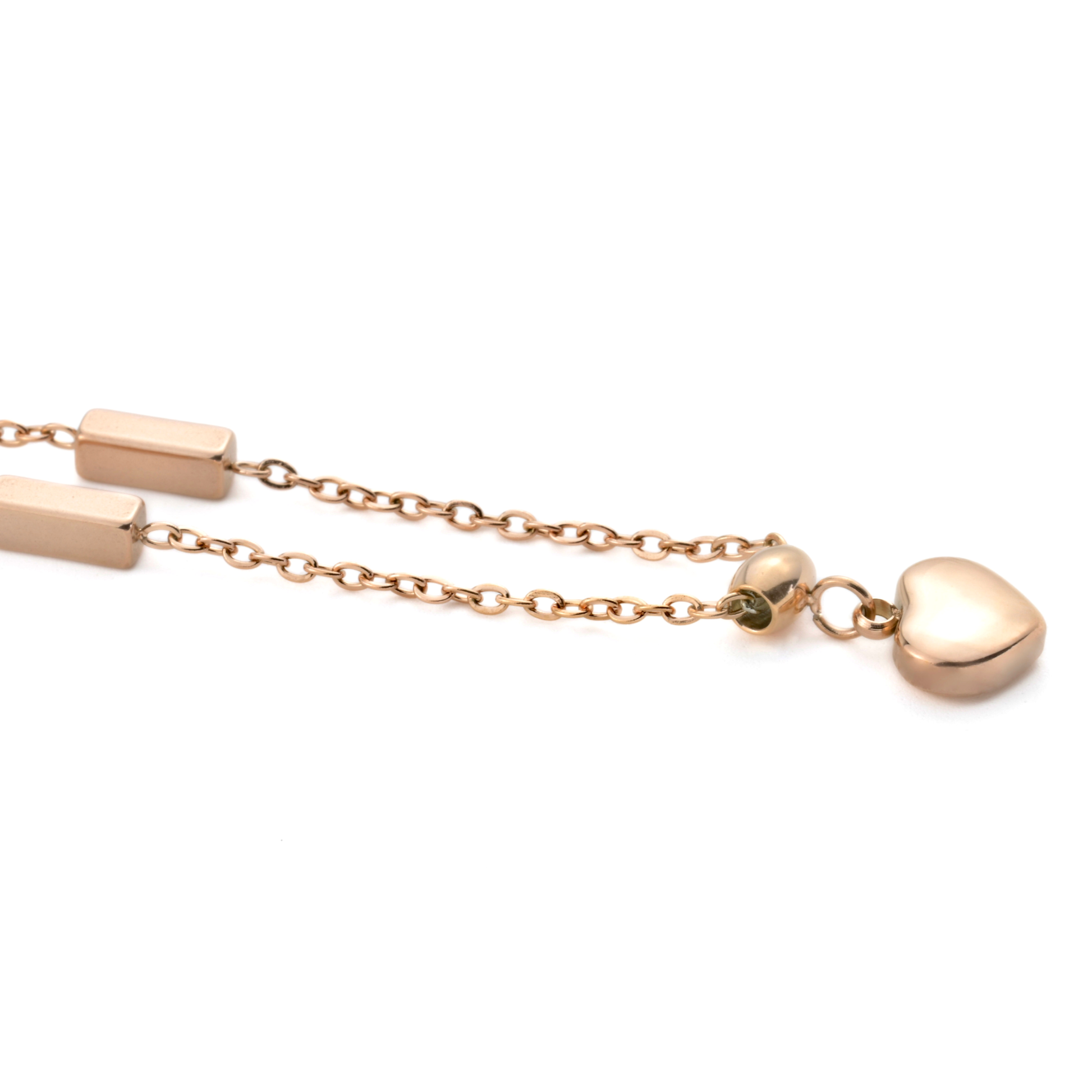 Rose gold ankle bracelet with heart charm on a white background