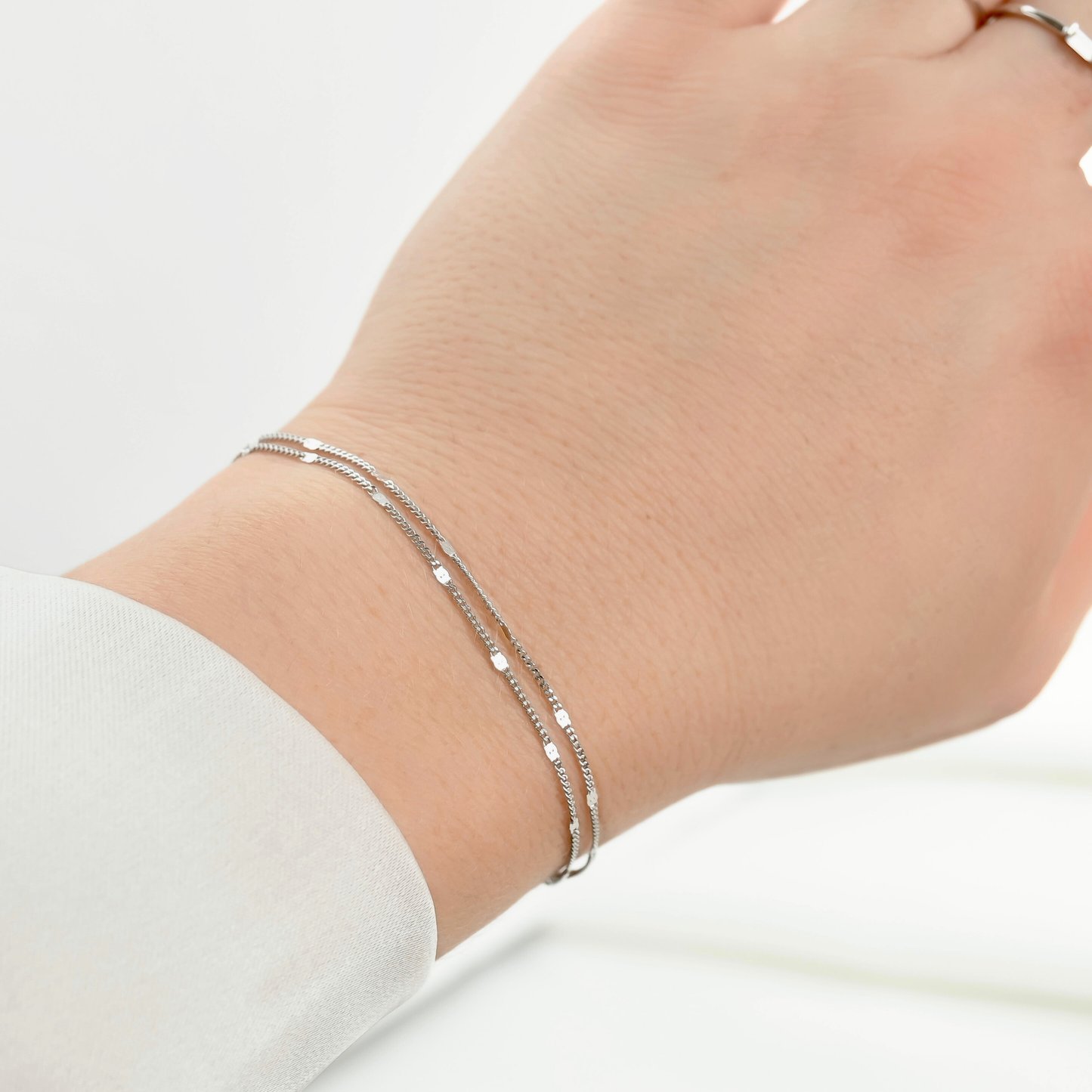 Silver layered bracelet on a wrist from a different angle