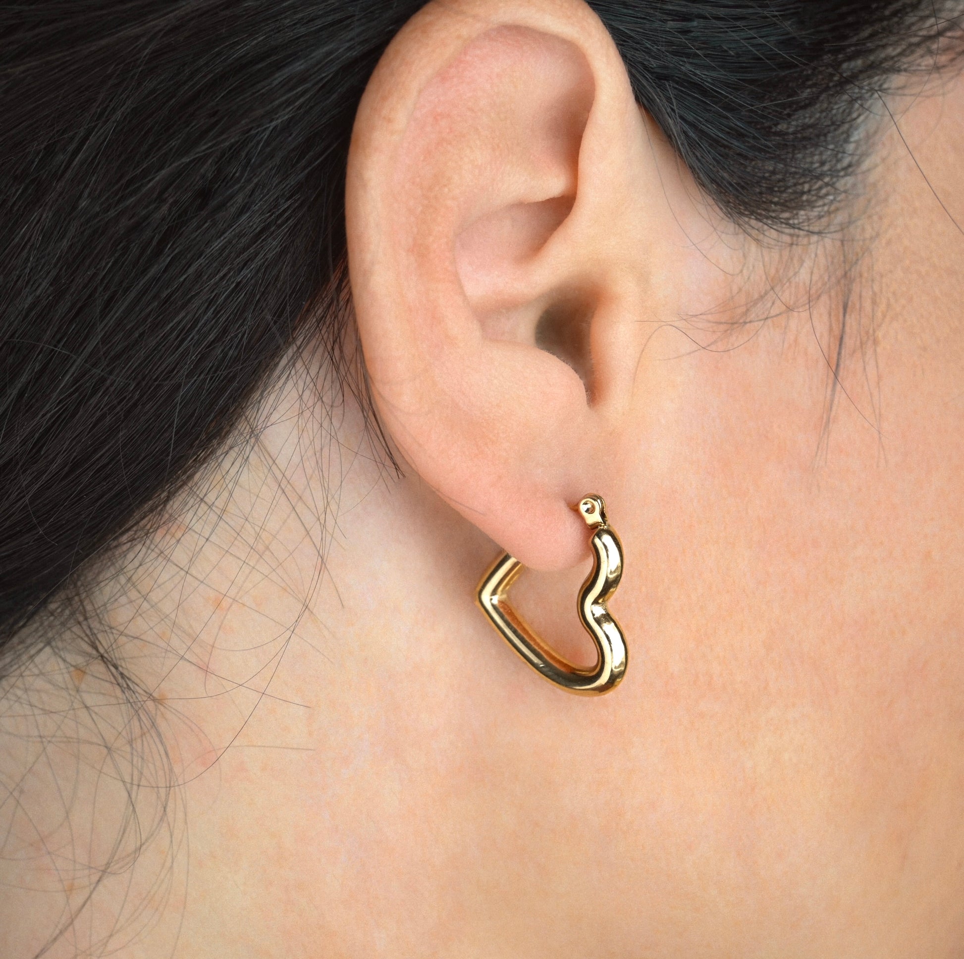 close up view of thick heart hoops on an ear