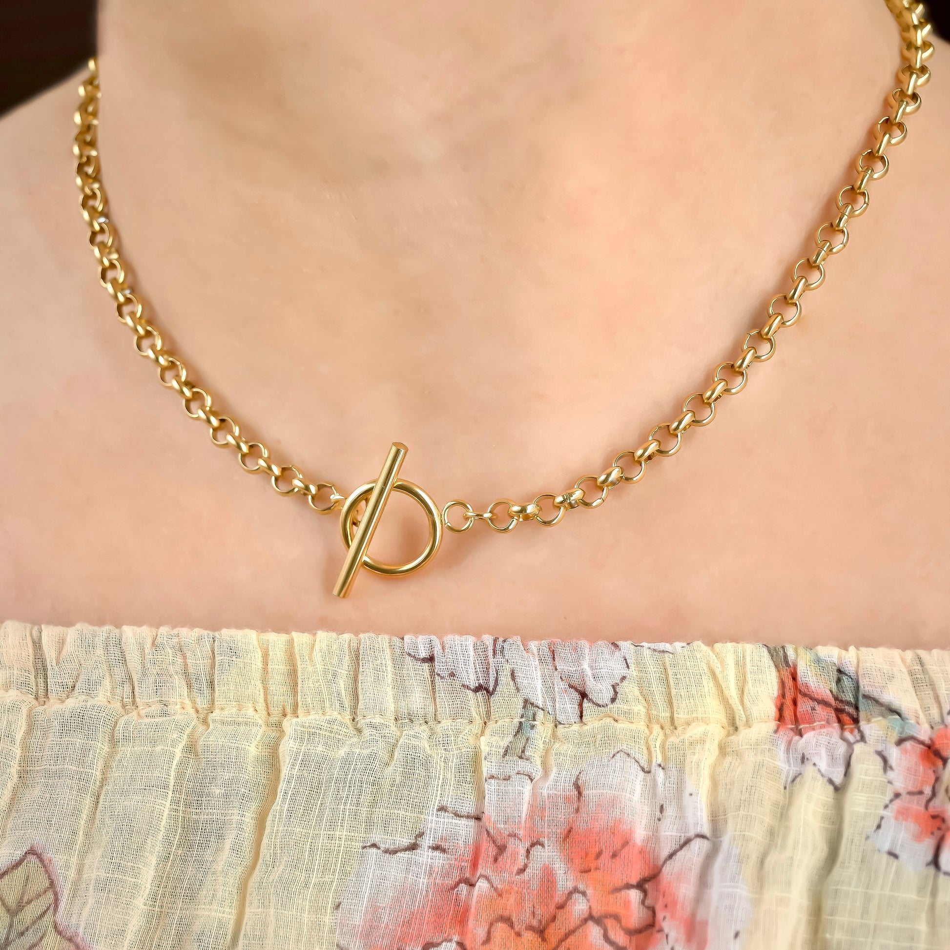 Chunky rolo necklace with a toggle clasp on a person wearing a floral sundress.