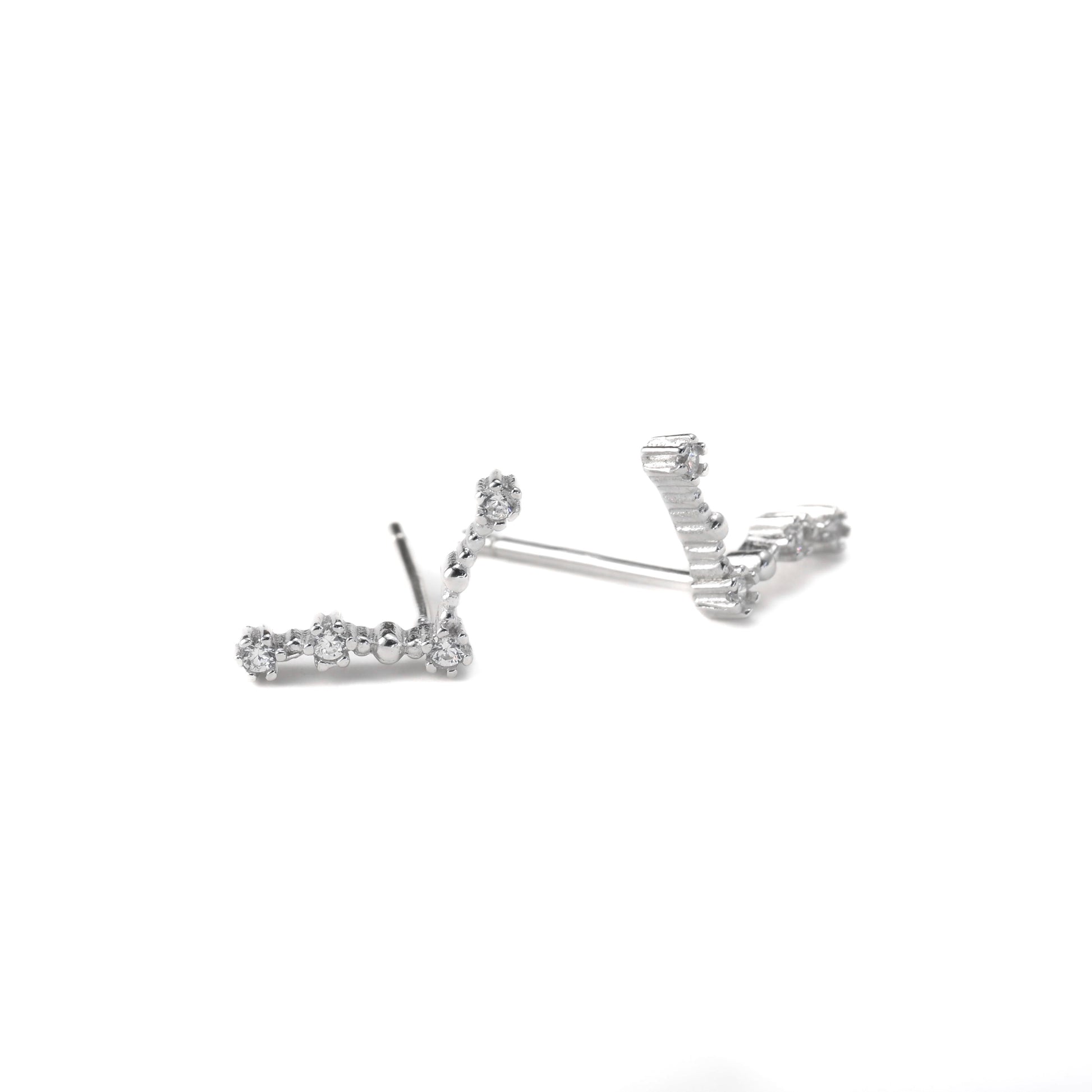 a pair of aries constellation stud earrings on a white background