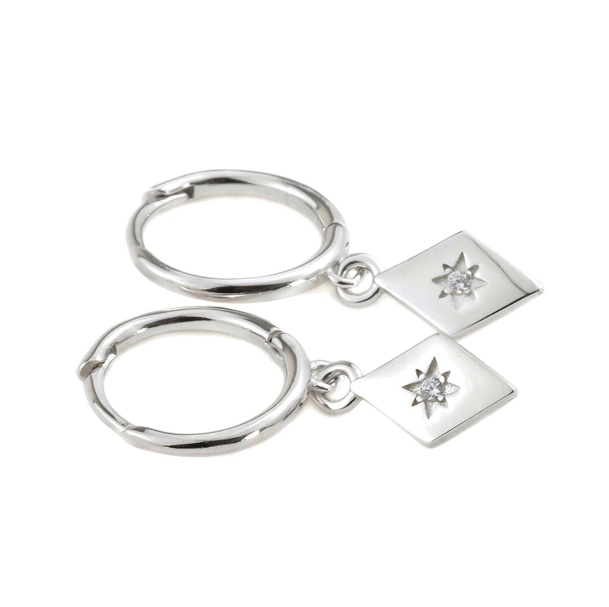 Silver earrings with diamond-shaped charms on a white background