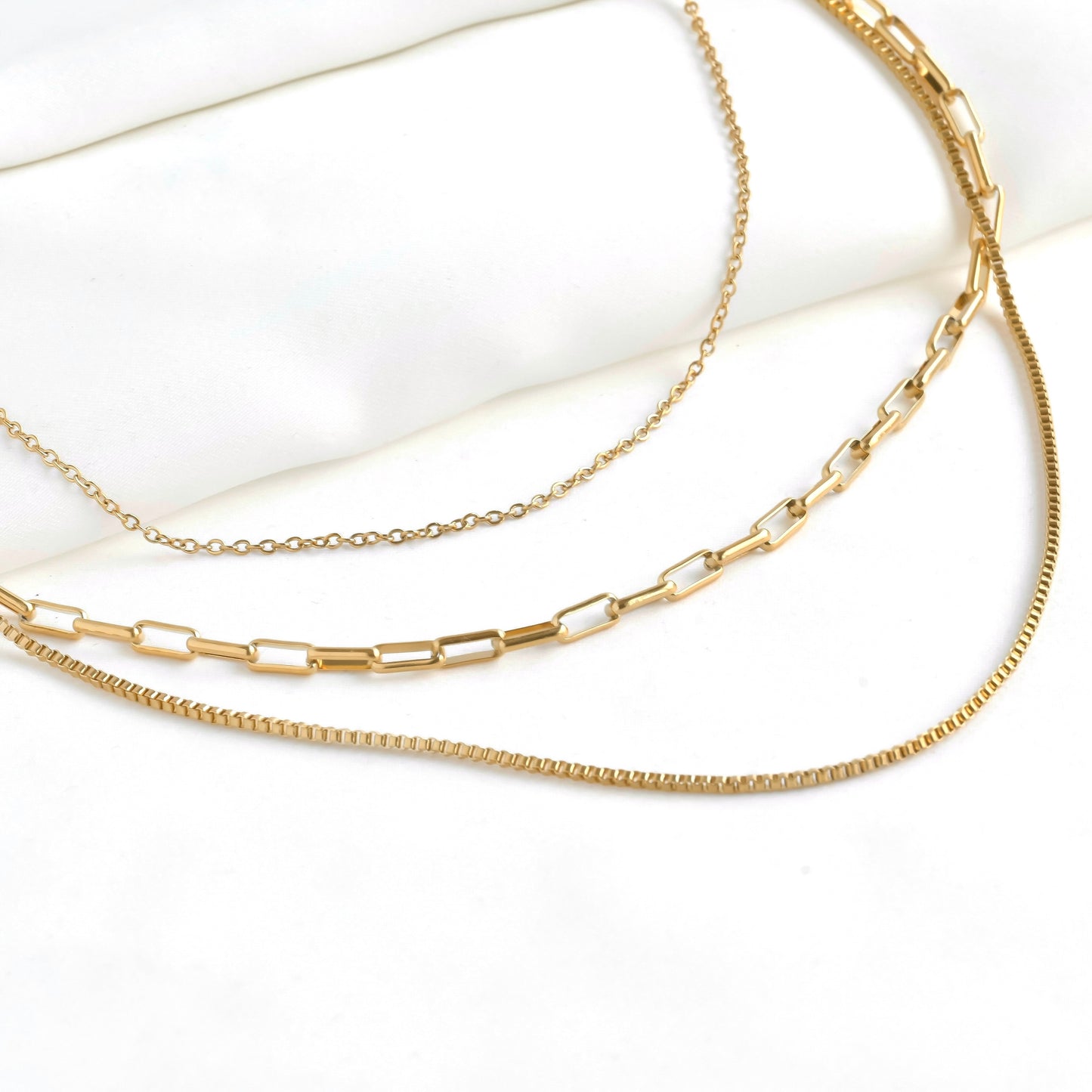 Three gold chains on a white background