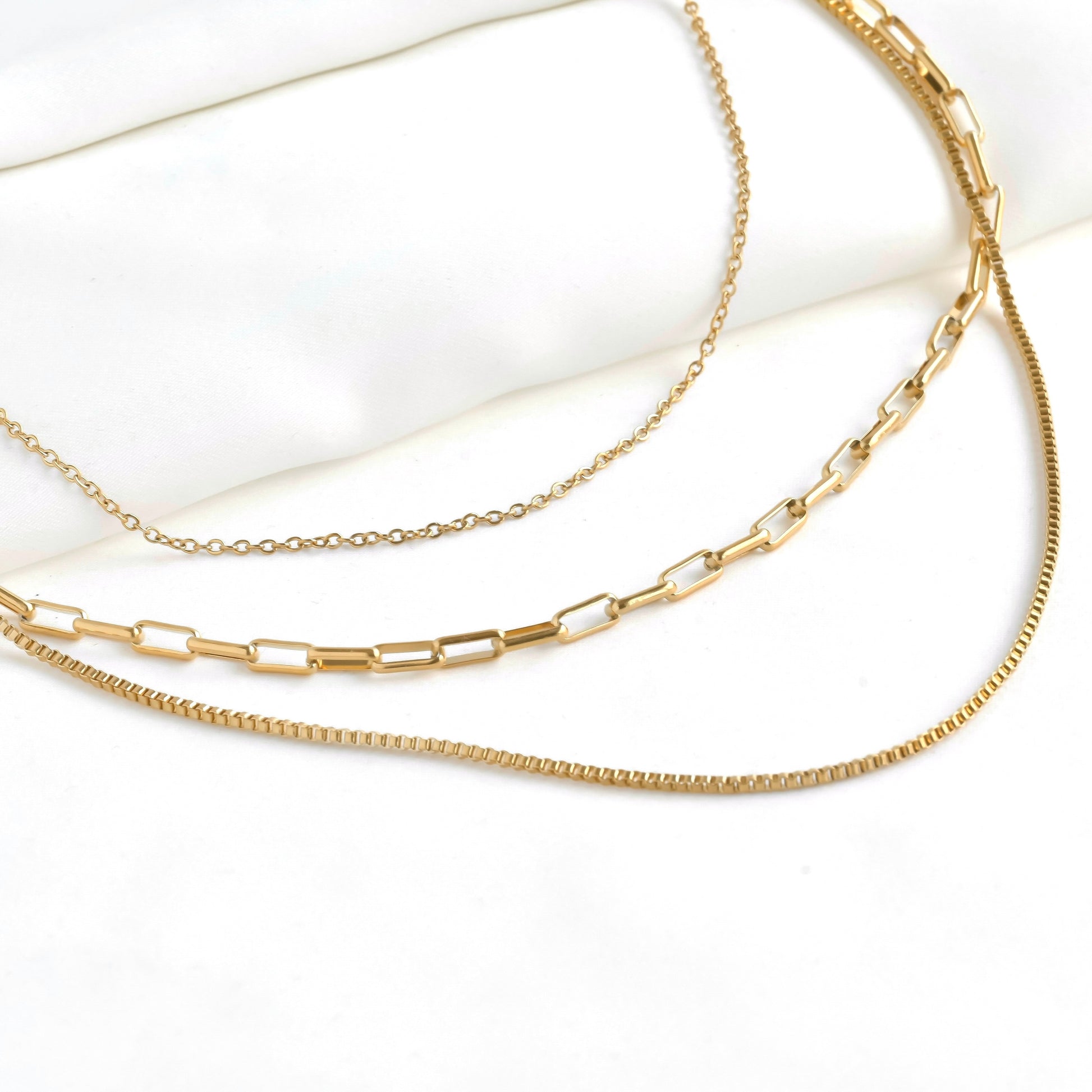 Three gold chains on a white background