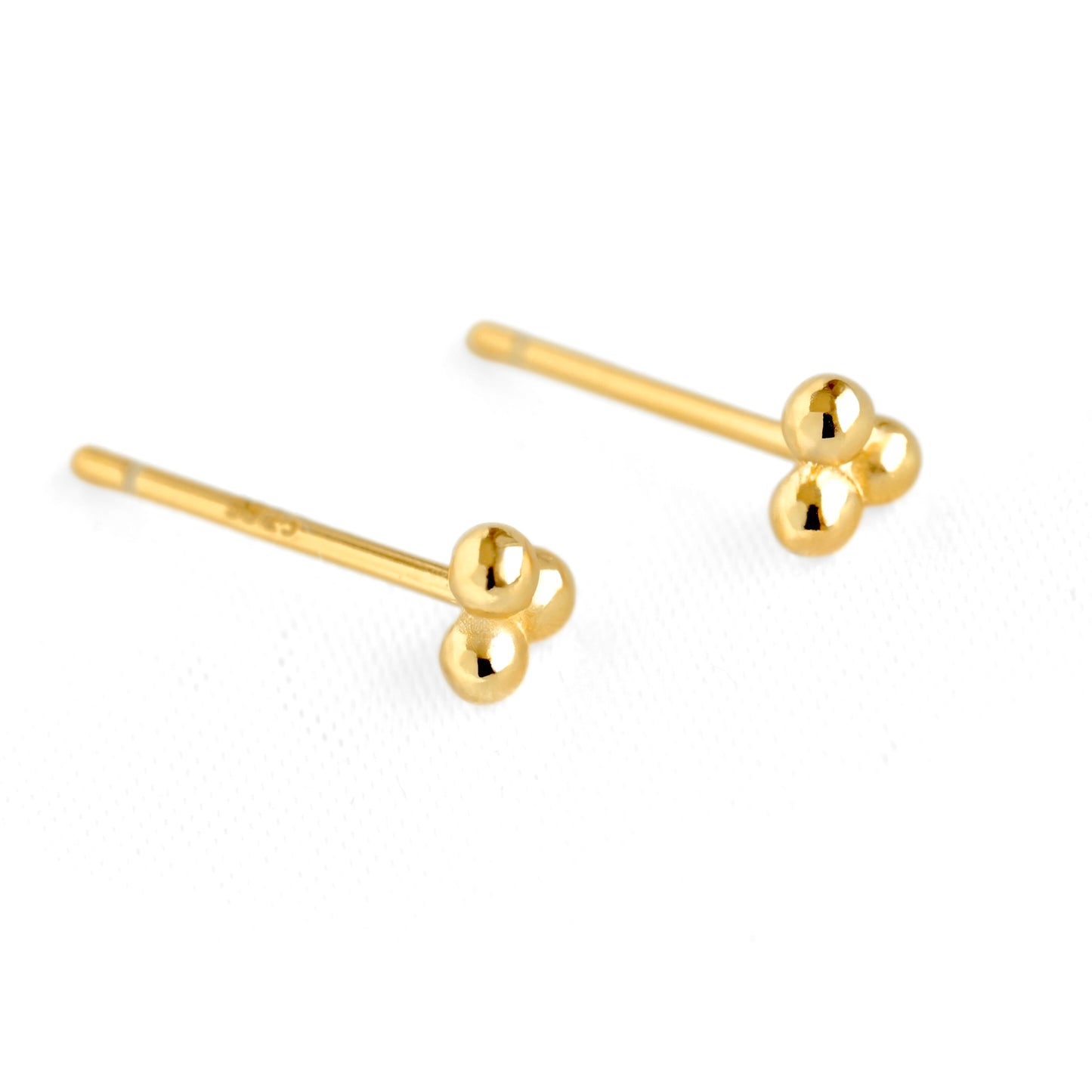 A pair of gold stud earrings with three small spherical beads clustered at the end of straight posts, shown on a clean white background.