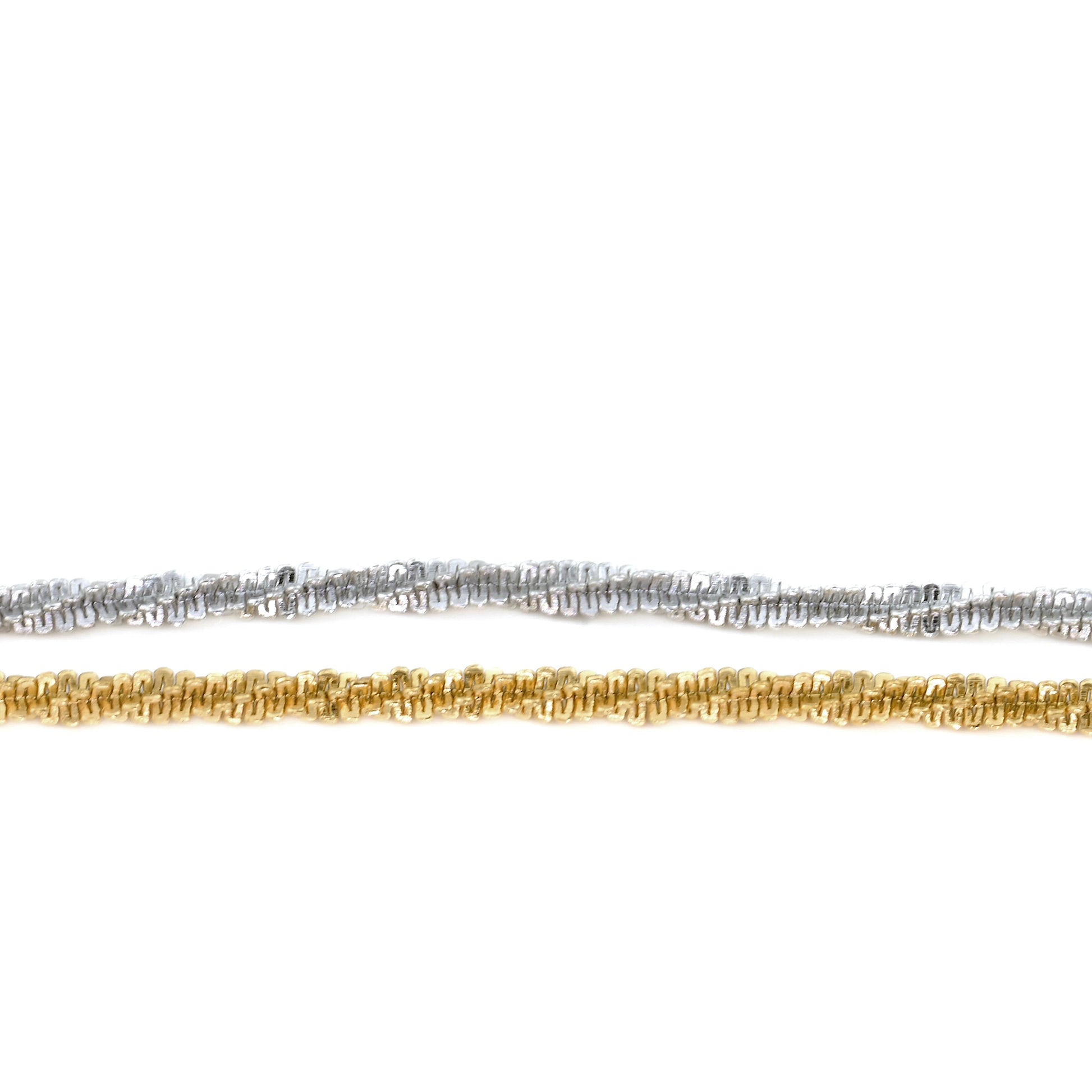 Close-up view of Two gold and silver chains horizontally placed on a white background