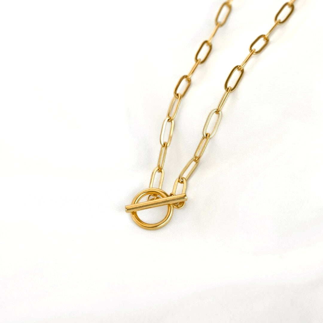 A gold paperclip chain necklace with a toggle clasp, photographed on a clean white background.