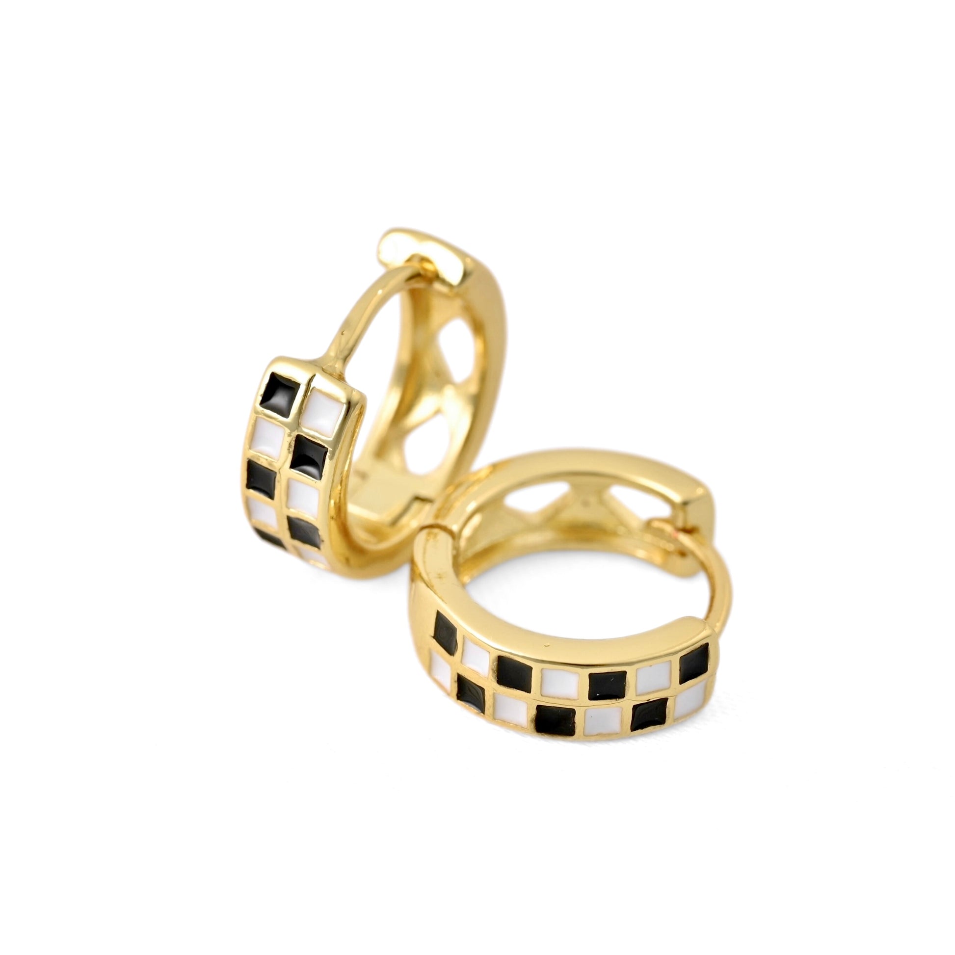 A pair of gold huggie hoop earrings with a checkered pattern of black and white square inlays, shown on a plain white background.