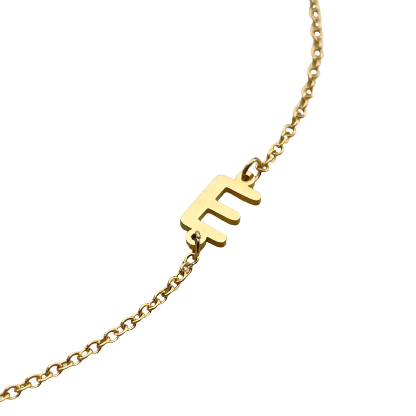 Close-up view of the letter charm 'E' reflecting light against a white background