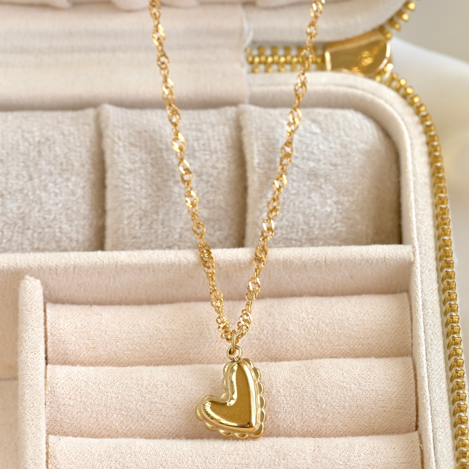 Gold heart pendant necklace in a beige jewelry box
