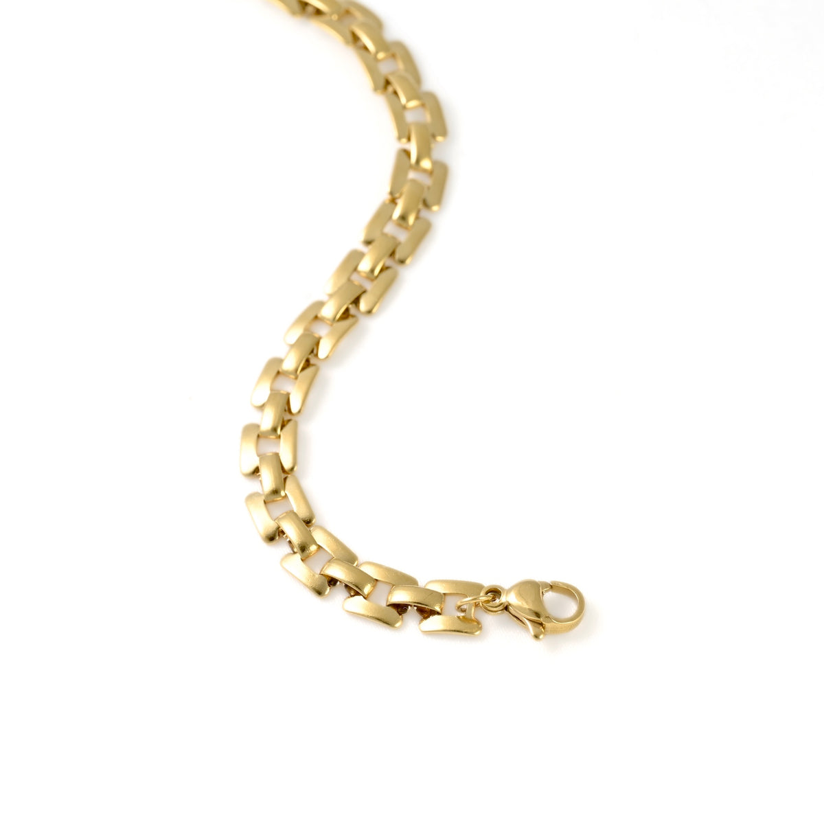 A close-up of a polished yellow gold curb link chain bracelet with a lobster clasp, shown against a solid white background.