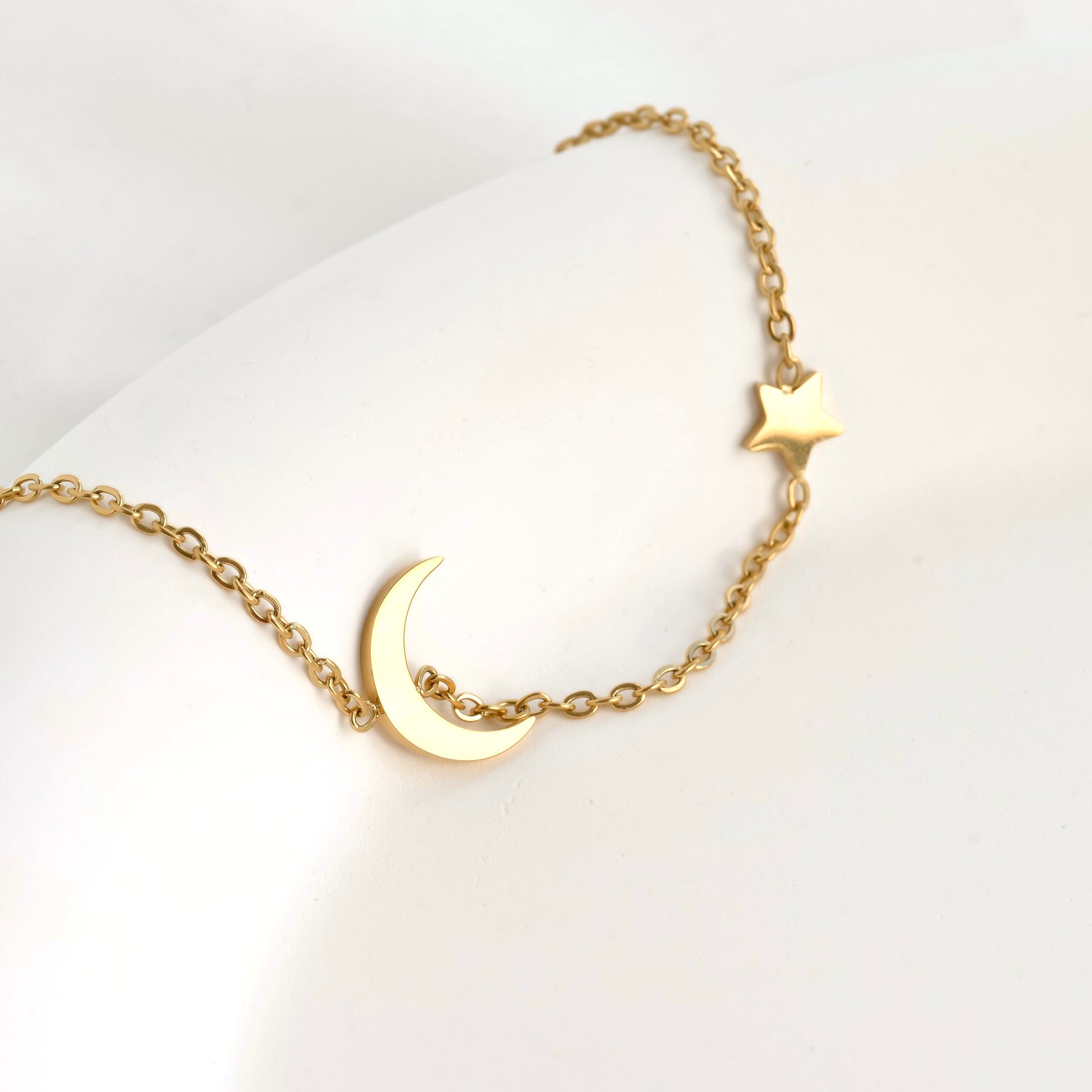 Gold crescent and star bracelet in a white dish