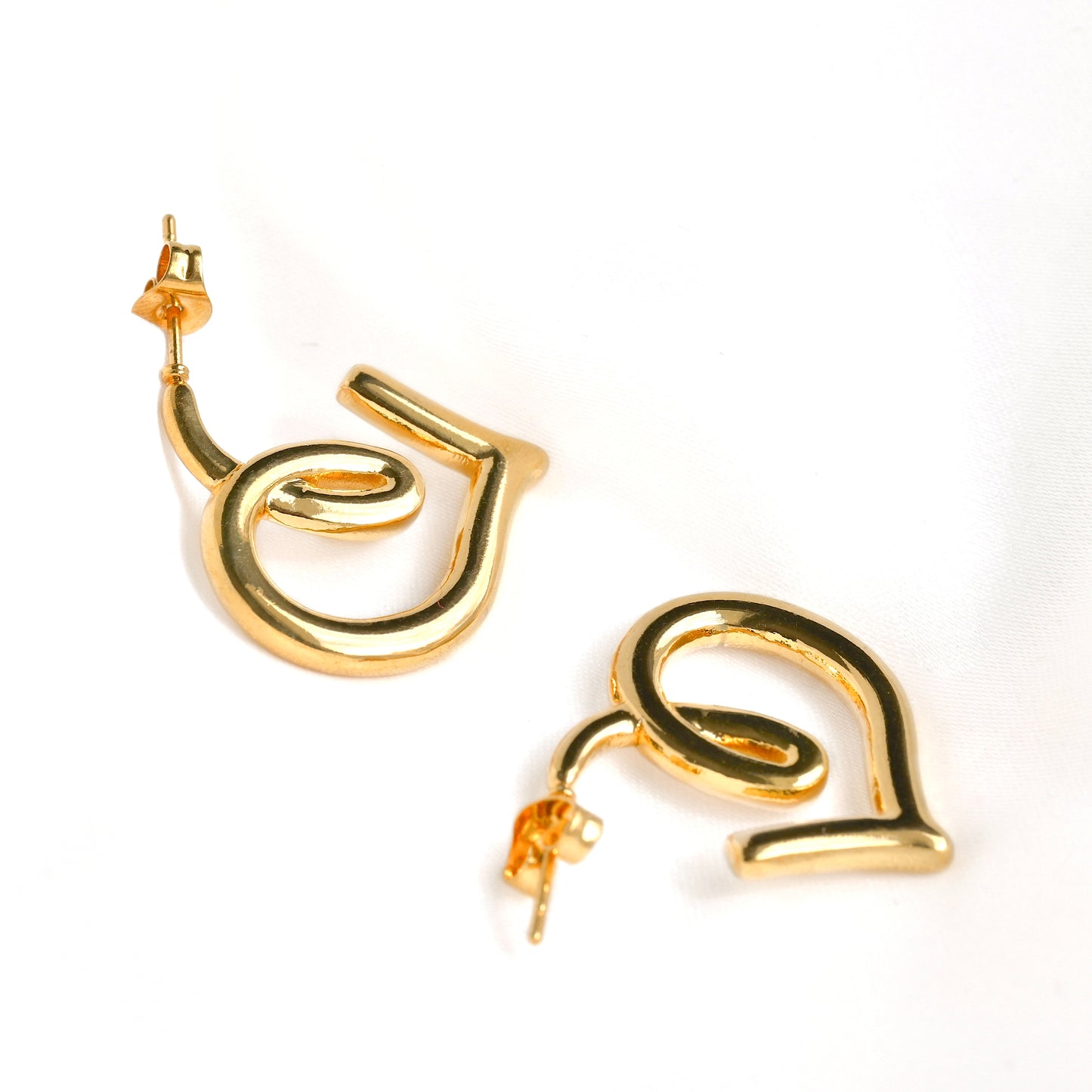 Gold spiral  heart earrings on a white background