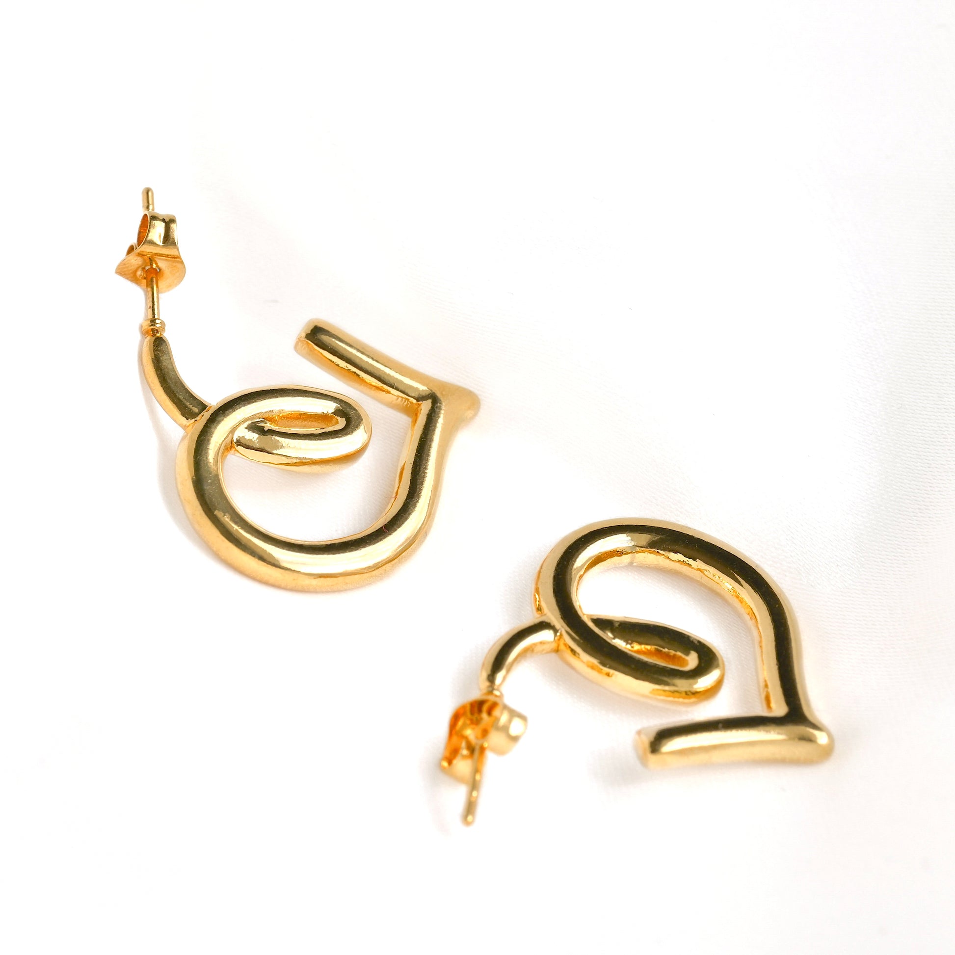 Gold spiral  heart earrings on a white background