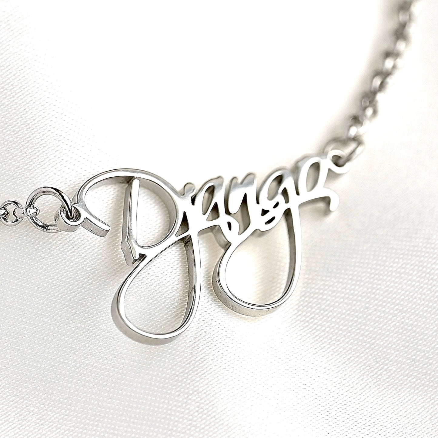Silver necklace with 'Django' pendant on a white background