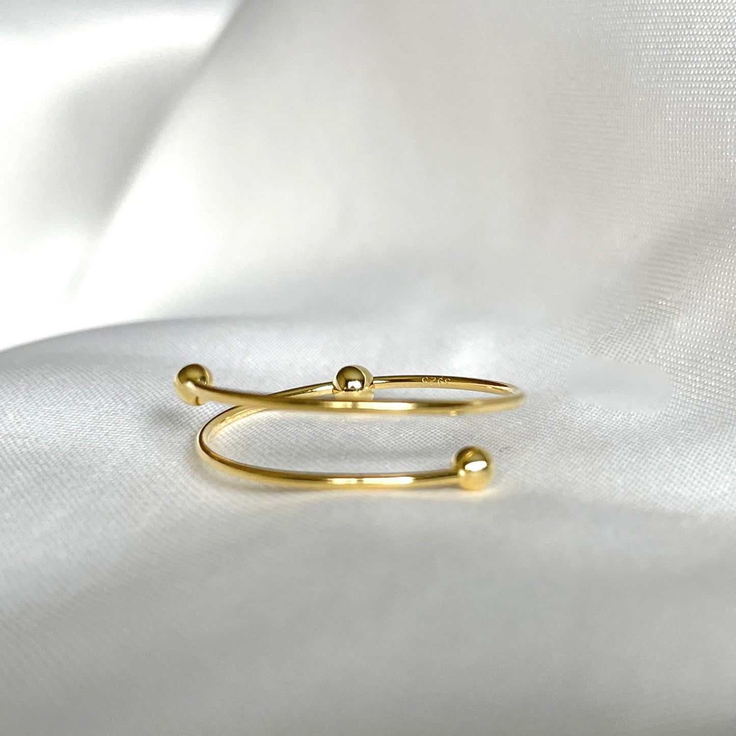 Gold ring on a white satin background