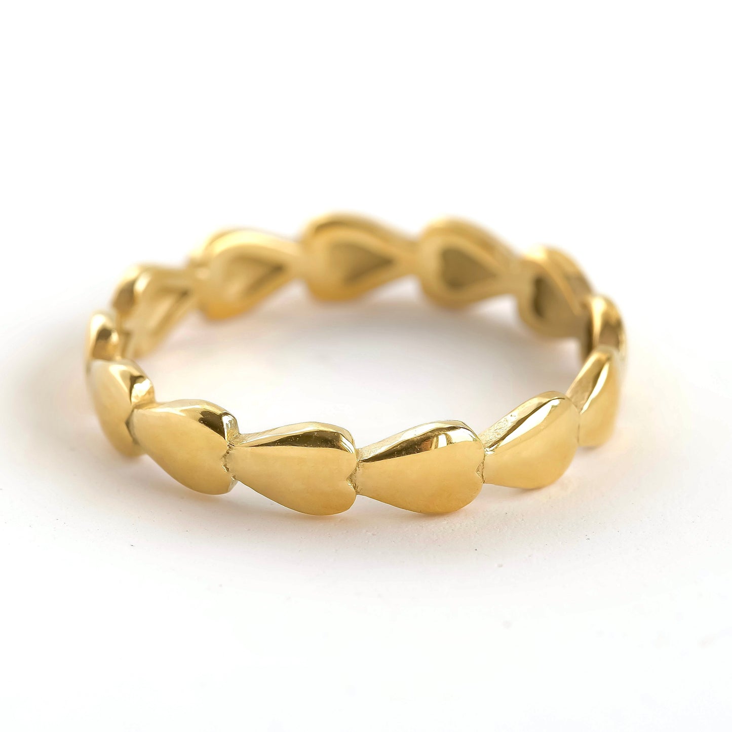 Gold ring with a heart chain design on a white background