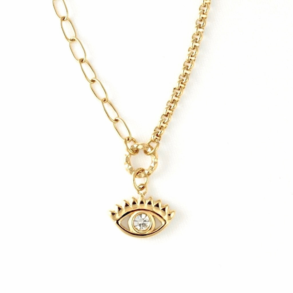 A gold-toned necklace featuring a paperclip&rolo chain and an evil eye pendant with a clear rhinestone, shown against a plain white background.