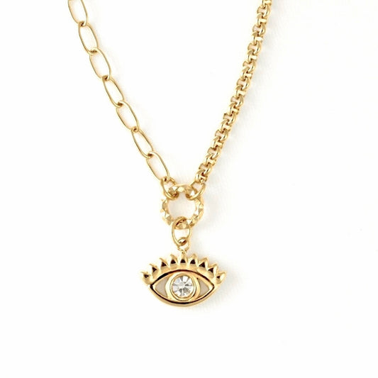 A gold-toned necklace featuring a paperclip&rolo chain and an evil eye pendant with a clear rhinestone, shown against a plain white background.