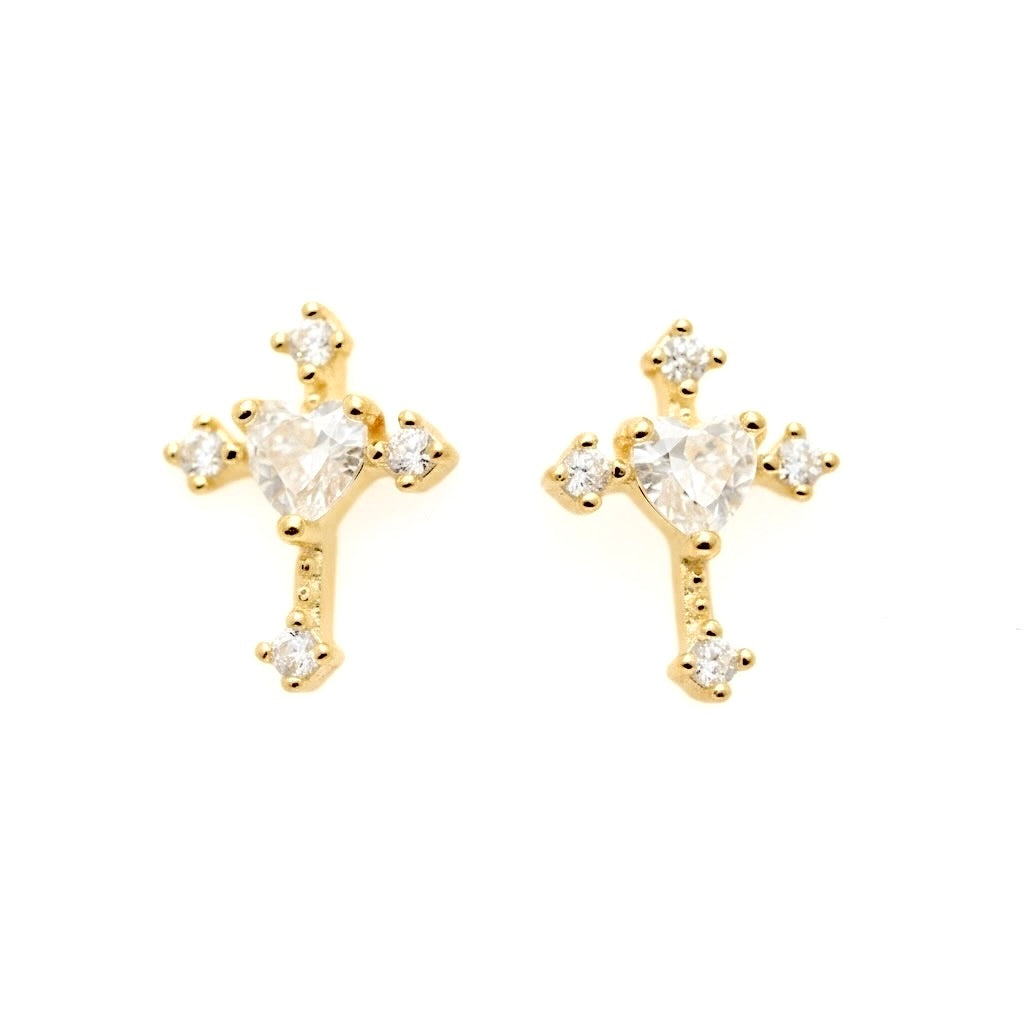 A pair of gold cross stud earrings, each featuring a central heart-shaped clear gemstone surrounded by smaller round and marquise-cut clear stones at the tips of the cross arms, set against a plain white background.