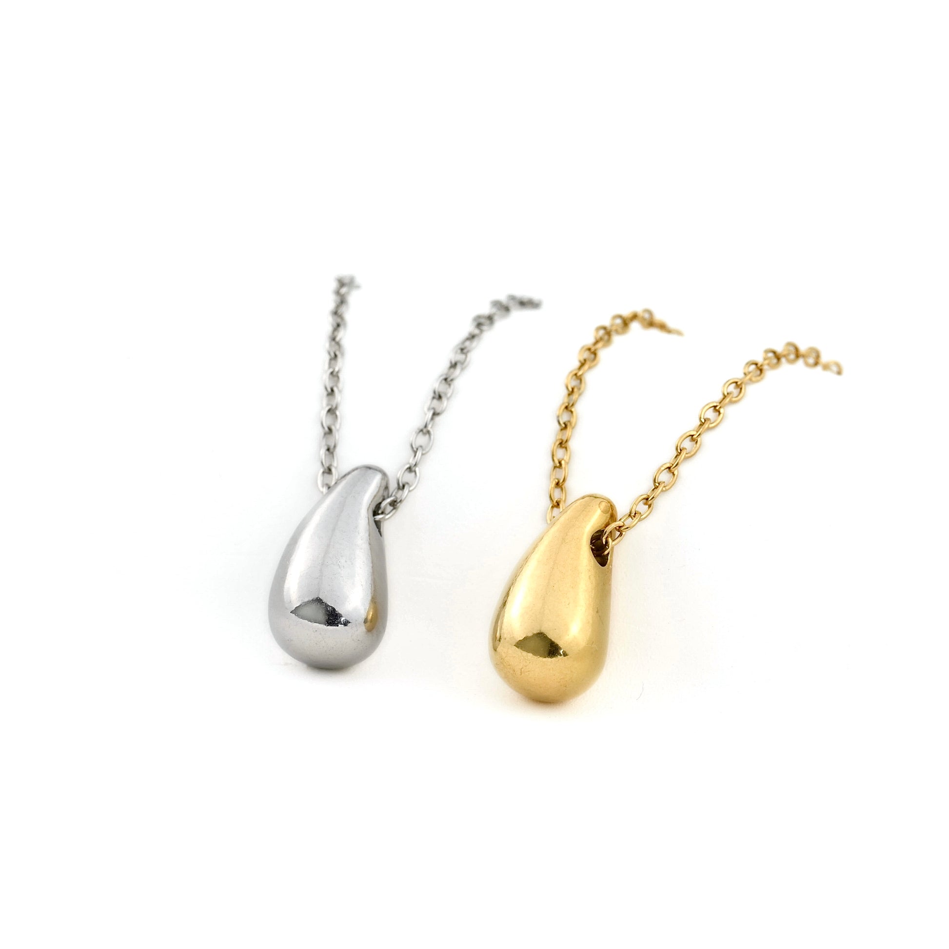Two necklaces with teardrop pendants, one silver and one gold, on a white background.