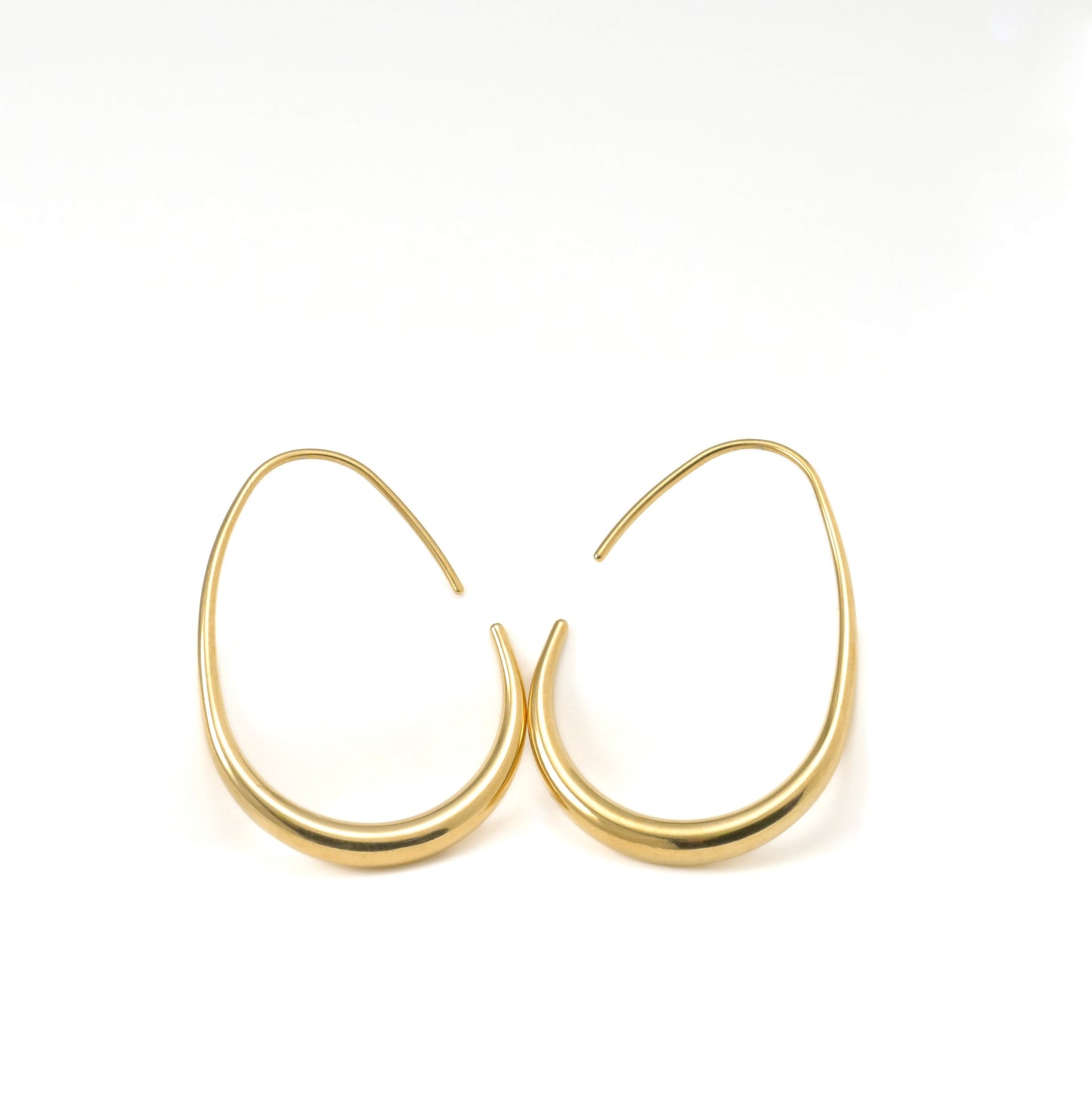 Gold teardrop hoop earrings on a white background