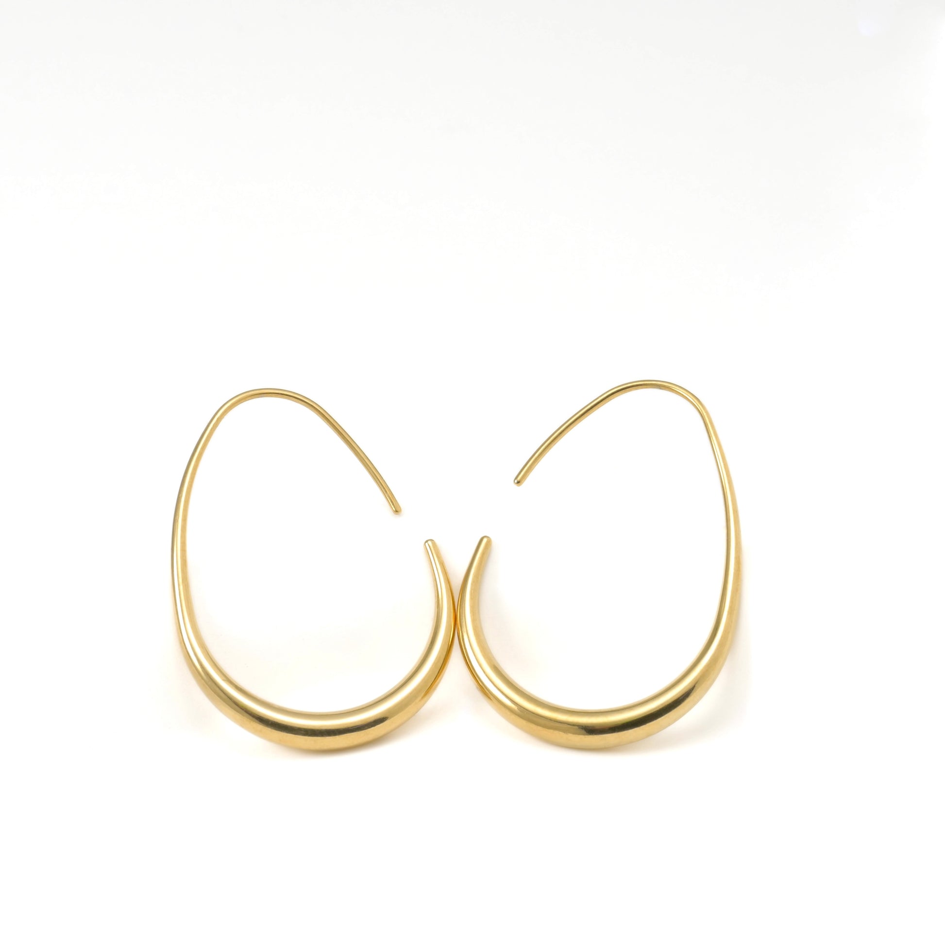 Gold teardrop hoop earrings on a white background