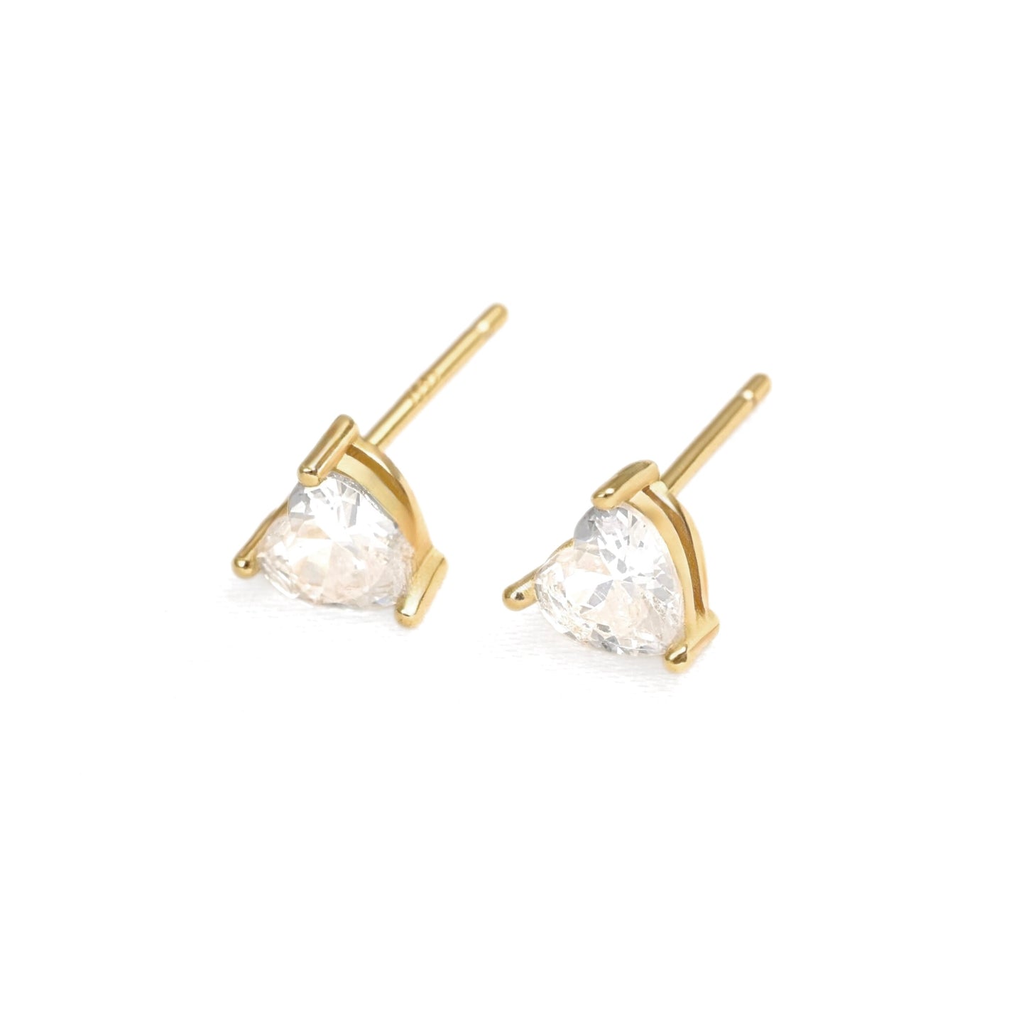 A pair of gold stud earrings with heart-shaped clear gemstones in a prong setting, shown on a plain white background.