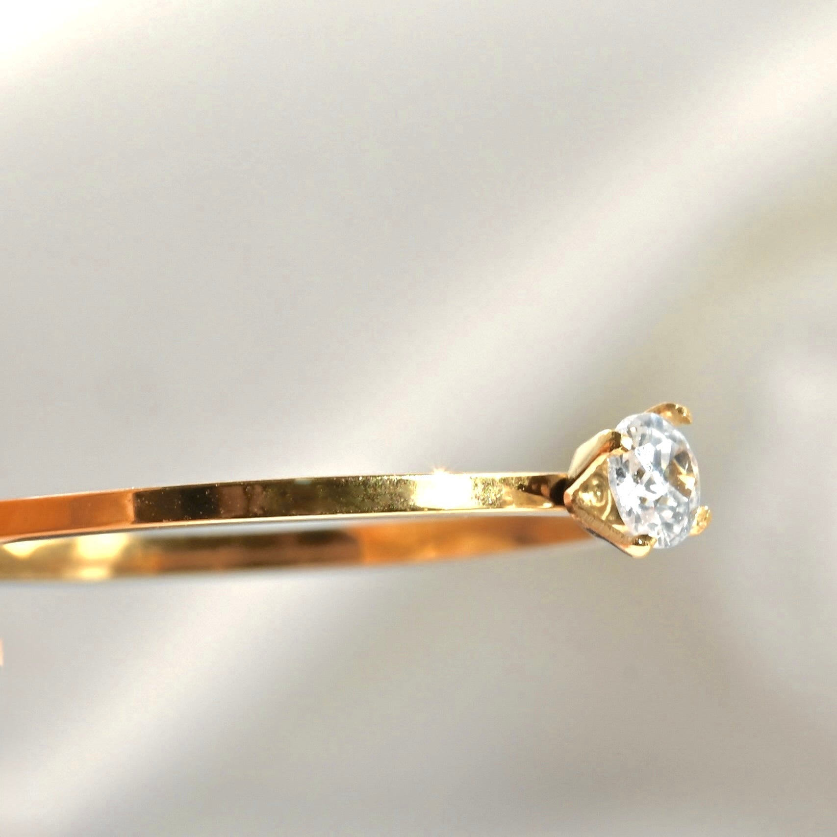 Close-up view of round CZ on the ring on a light gray background