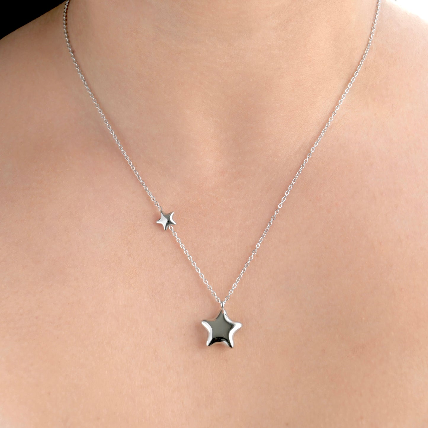 Front view of silver star necklace on a person's neck