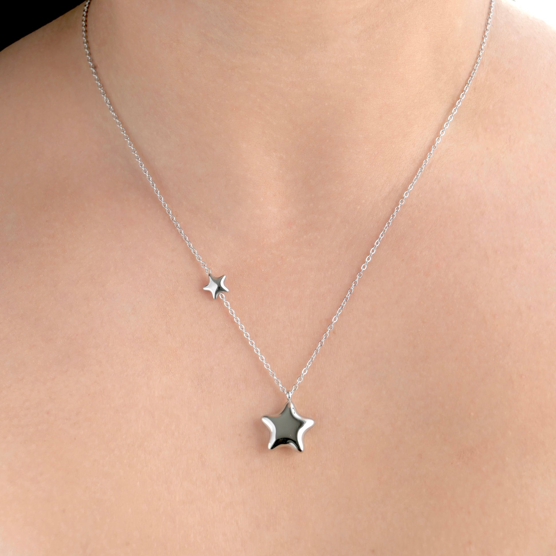 Front view of silver star necklace on a person's neck