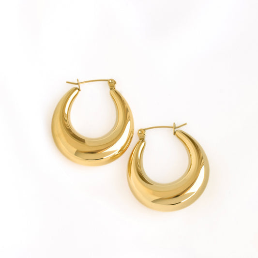A pair of polished gold crescent-shaped hoop earrings on a clean white background.