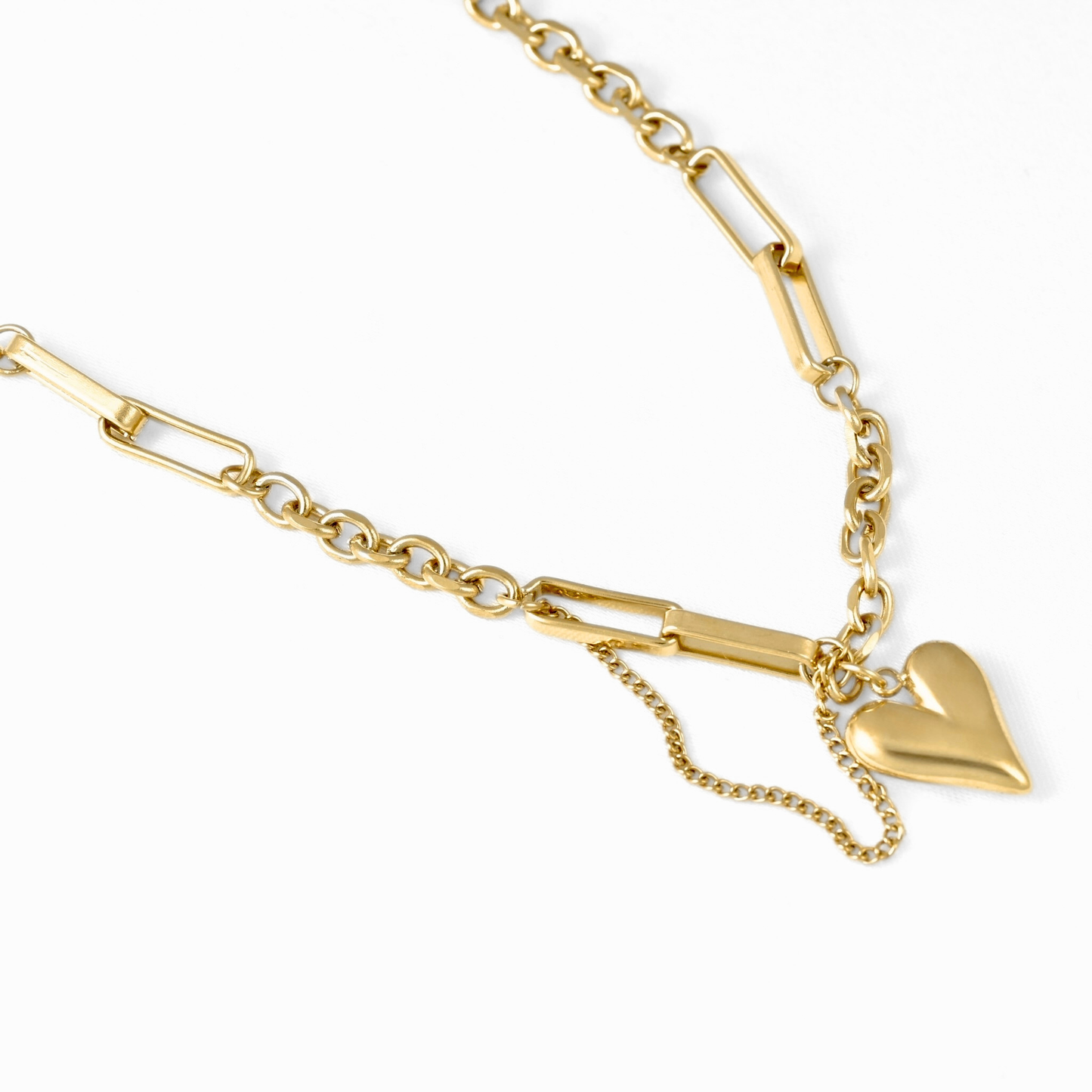A gold-toned chain bracelet featuring a small polished heart charm and a short dangling chain, displayed on a clean white background.