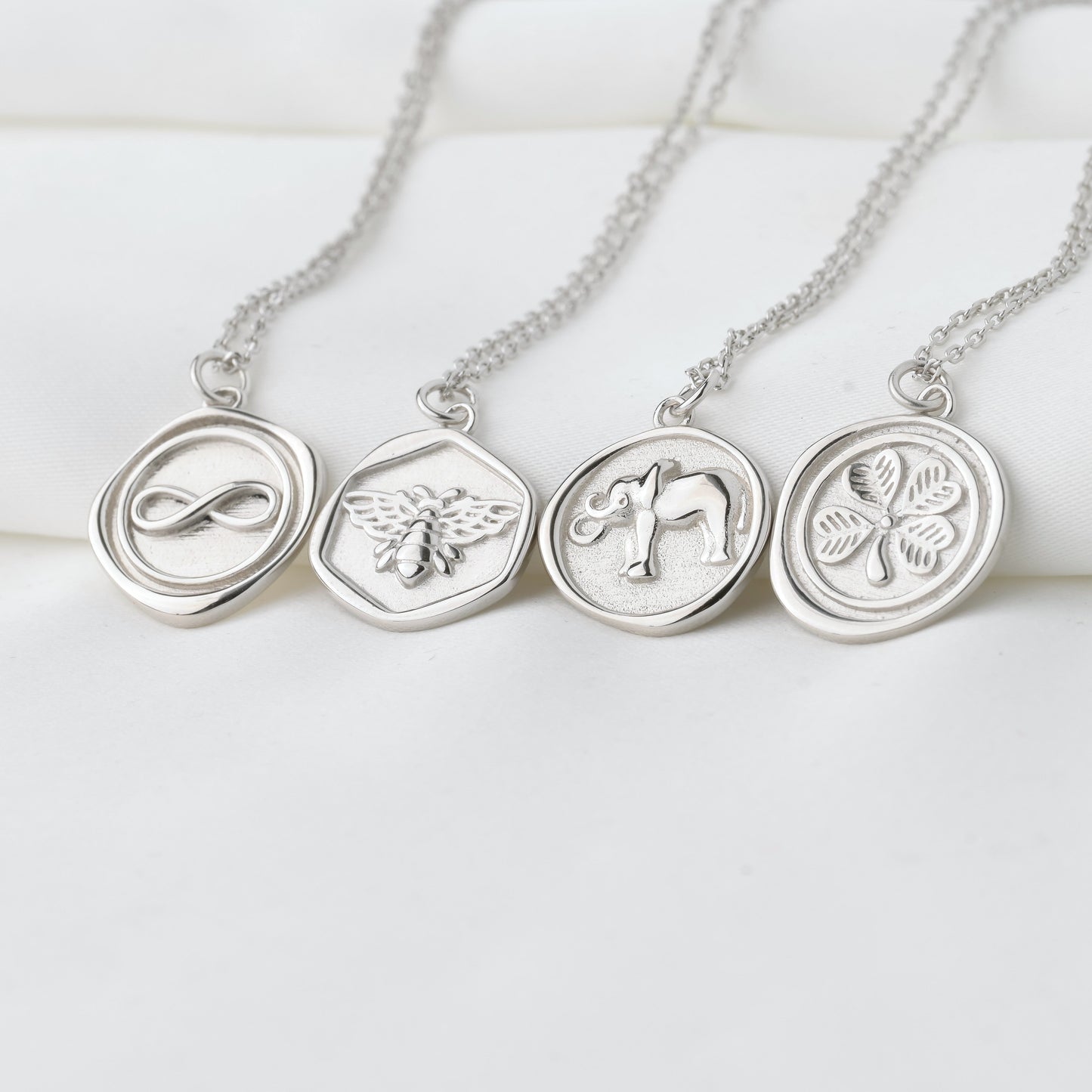 Silver necklaces with circular pendants on a white background