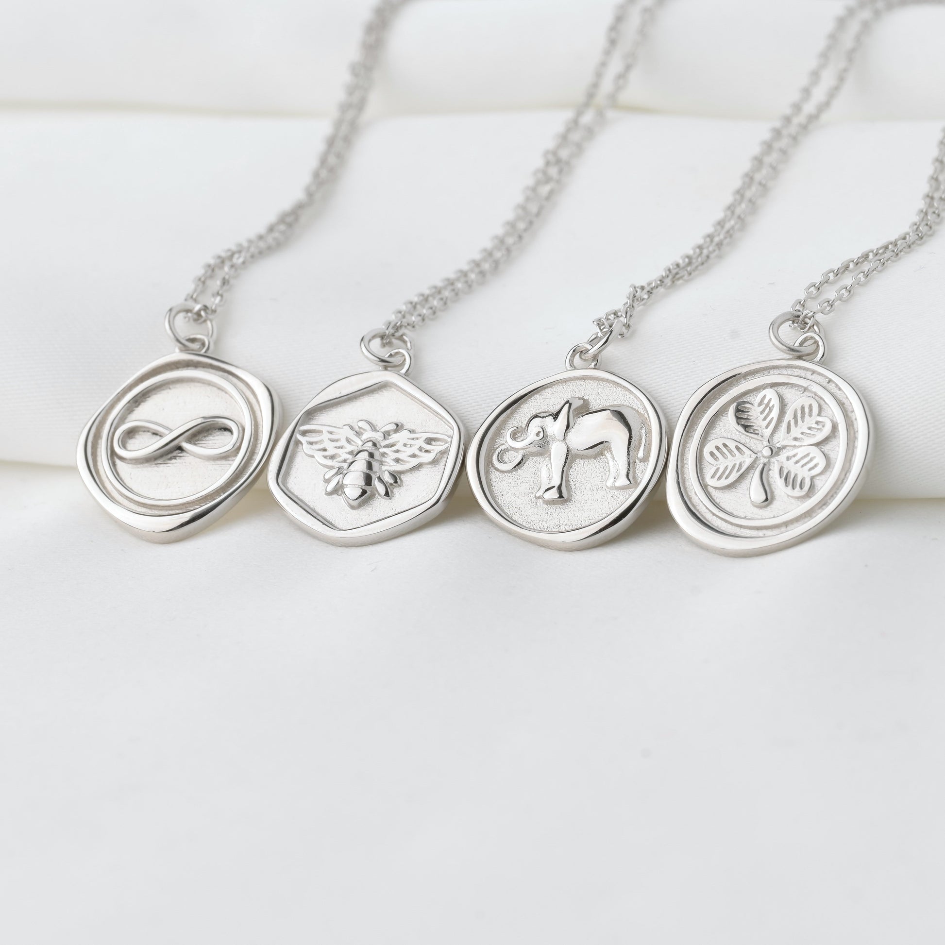 Silver necklaces with circular pendants on a white background
