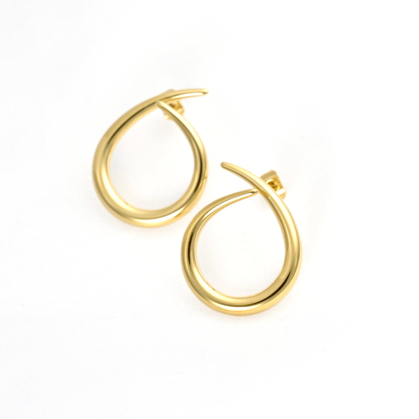 A pair of polished gold teardrop-shaped hoop earrings on a clean white background.