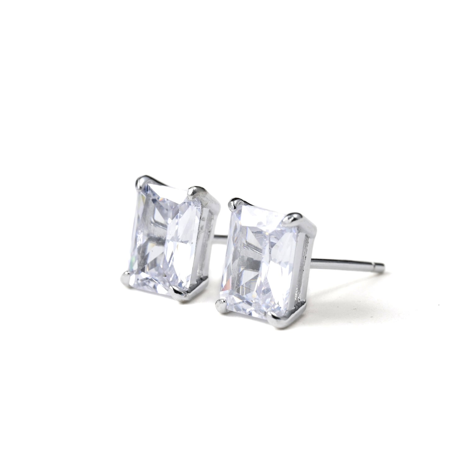 Pair of silver stud earrings with rectangular clear gemstones on a white background