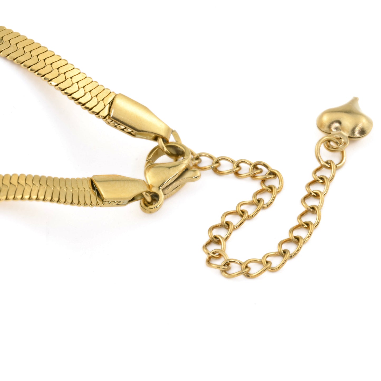 Close-up view of the clasp area of gold herringbone anklet with a lobster clasp and a chain extension with a tinny puffy heart charm at the end, on a white background