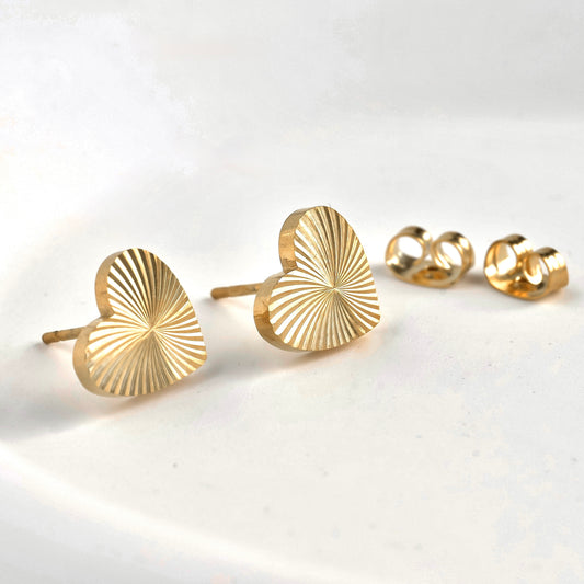 Gold spiral ribbed heart stud earrings on a white background