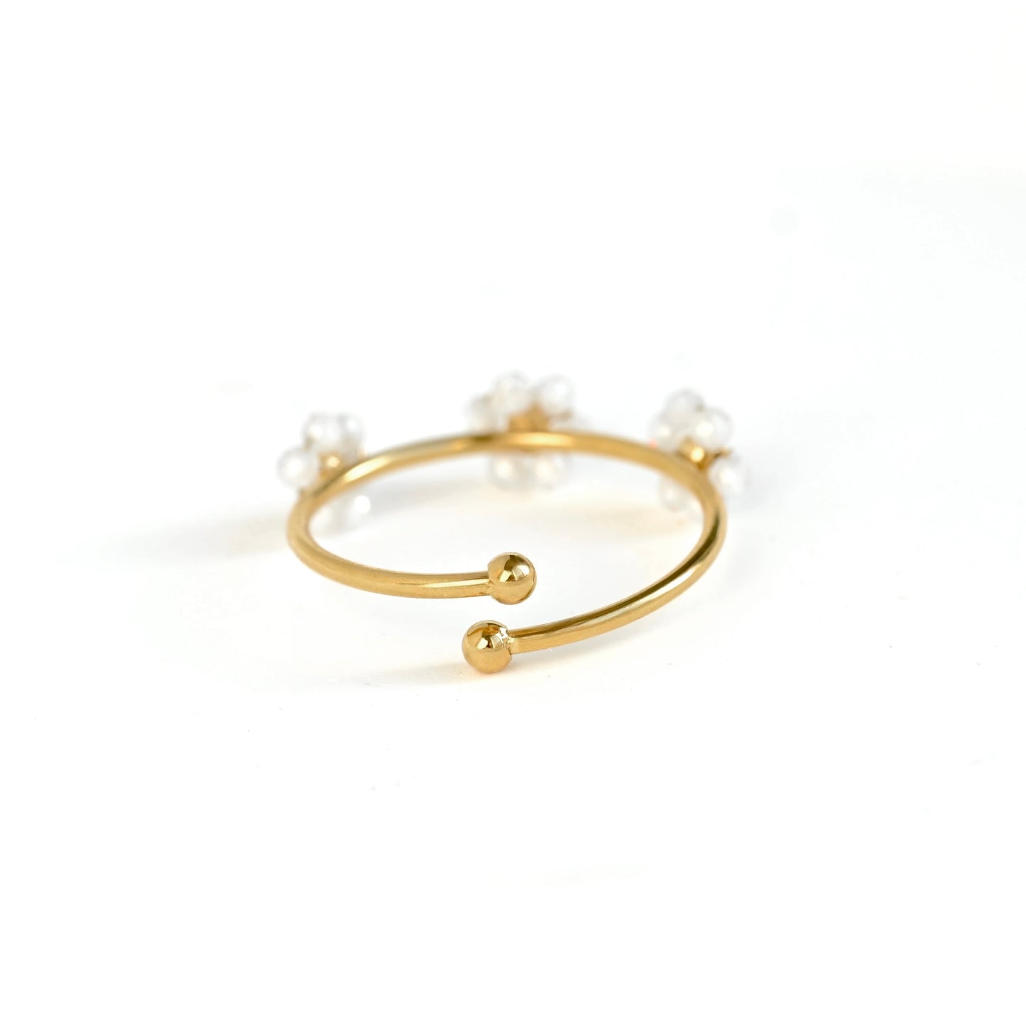 Back view of a gold-plated open wrap ring ring decorated with small white pearl-like beads and two oerlapping ball ends, shown on a clean white background.